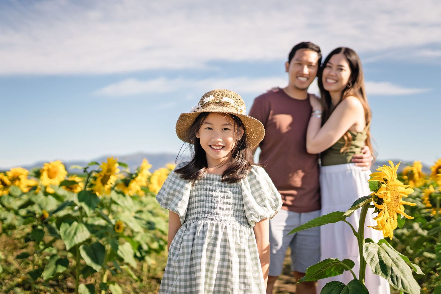 People enjoying a sunny day in a vibrant yellow sunflower field during summer.