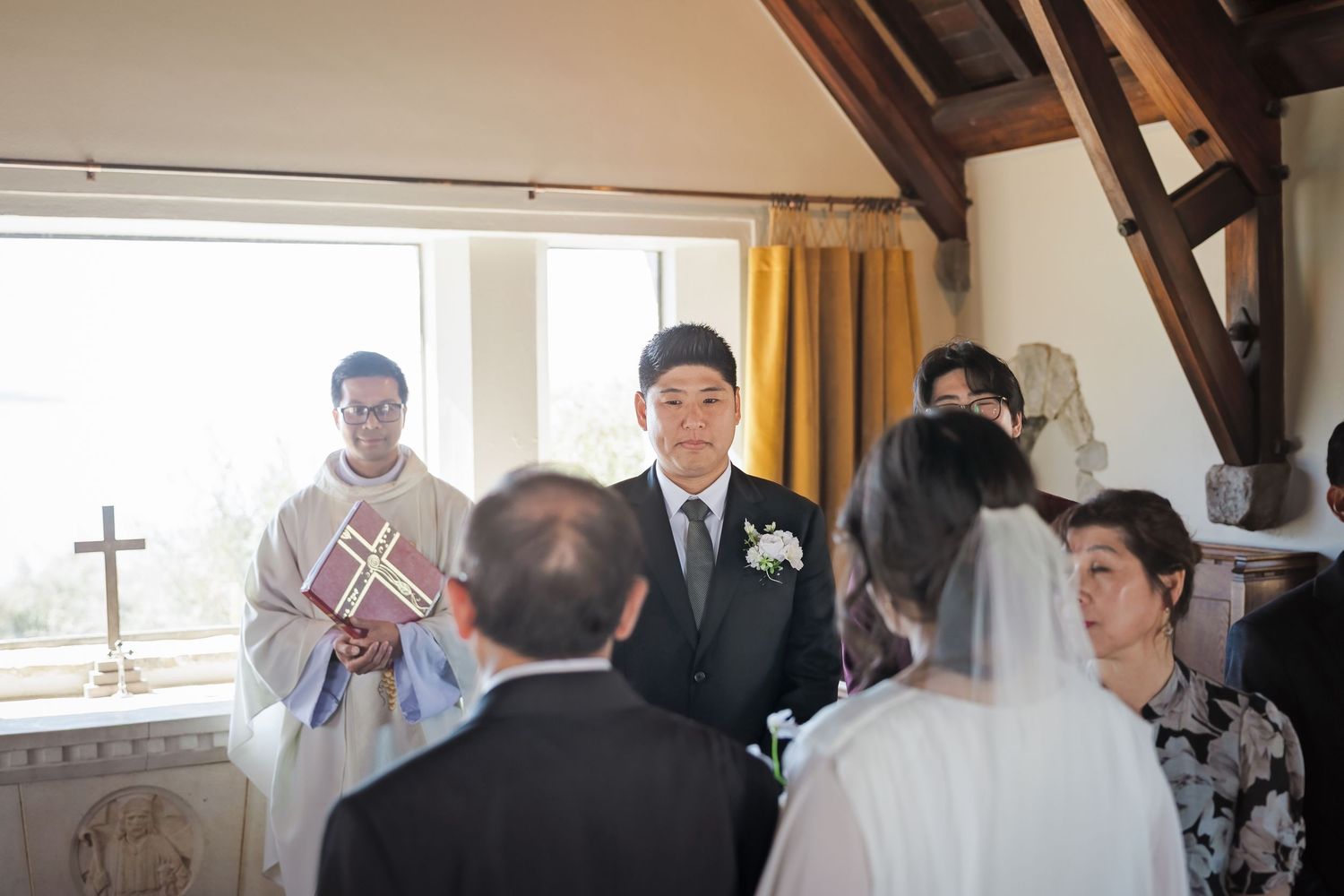 Groom standing at altar during intimate chapel wedding ceremony.