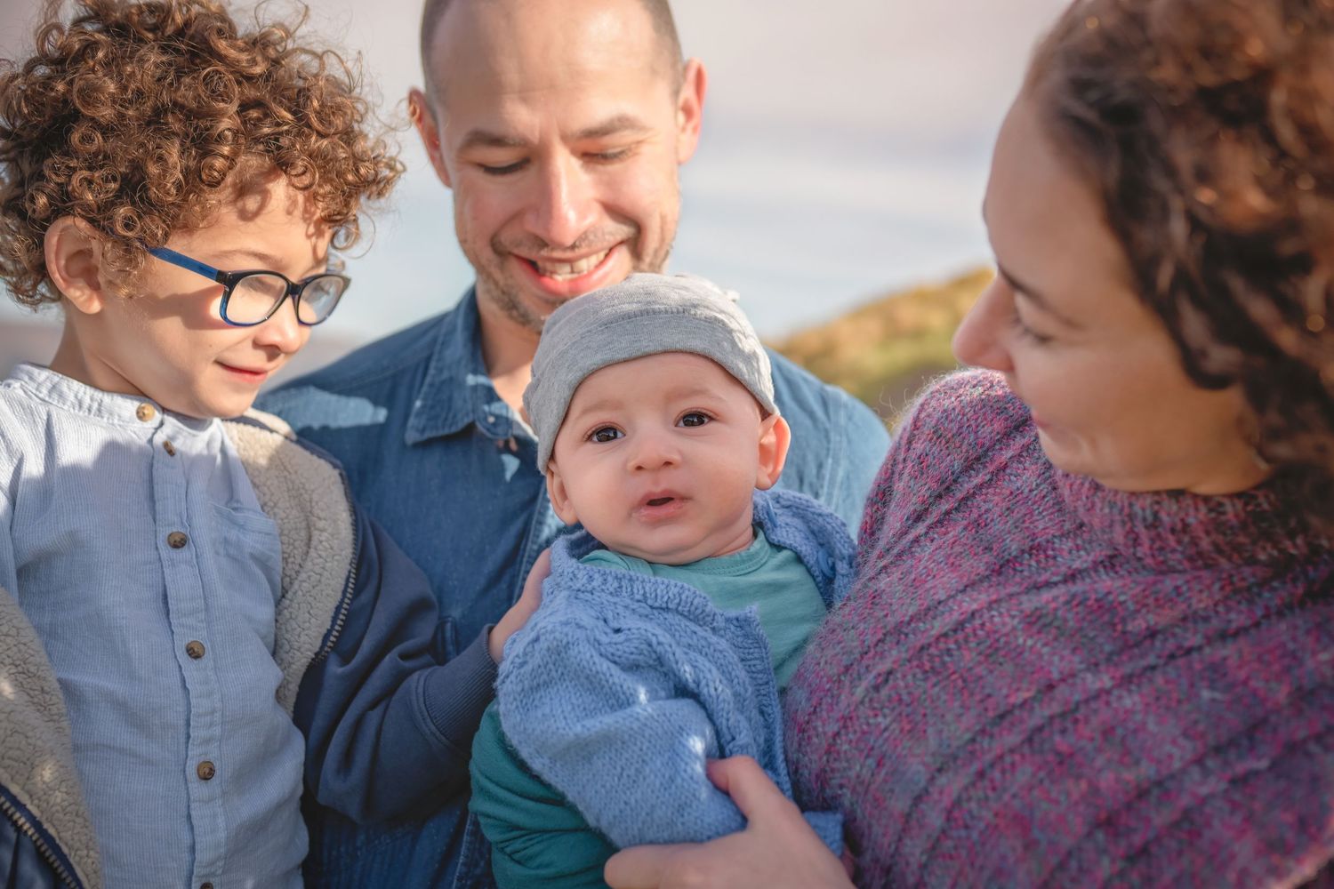 Intimate family portrait outdoors with natural lighting and warm expressions.