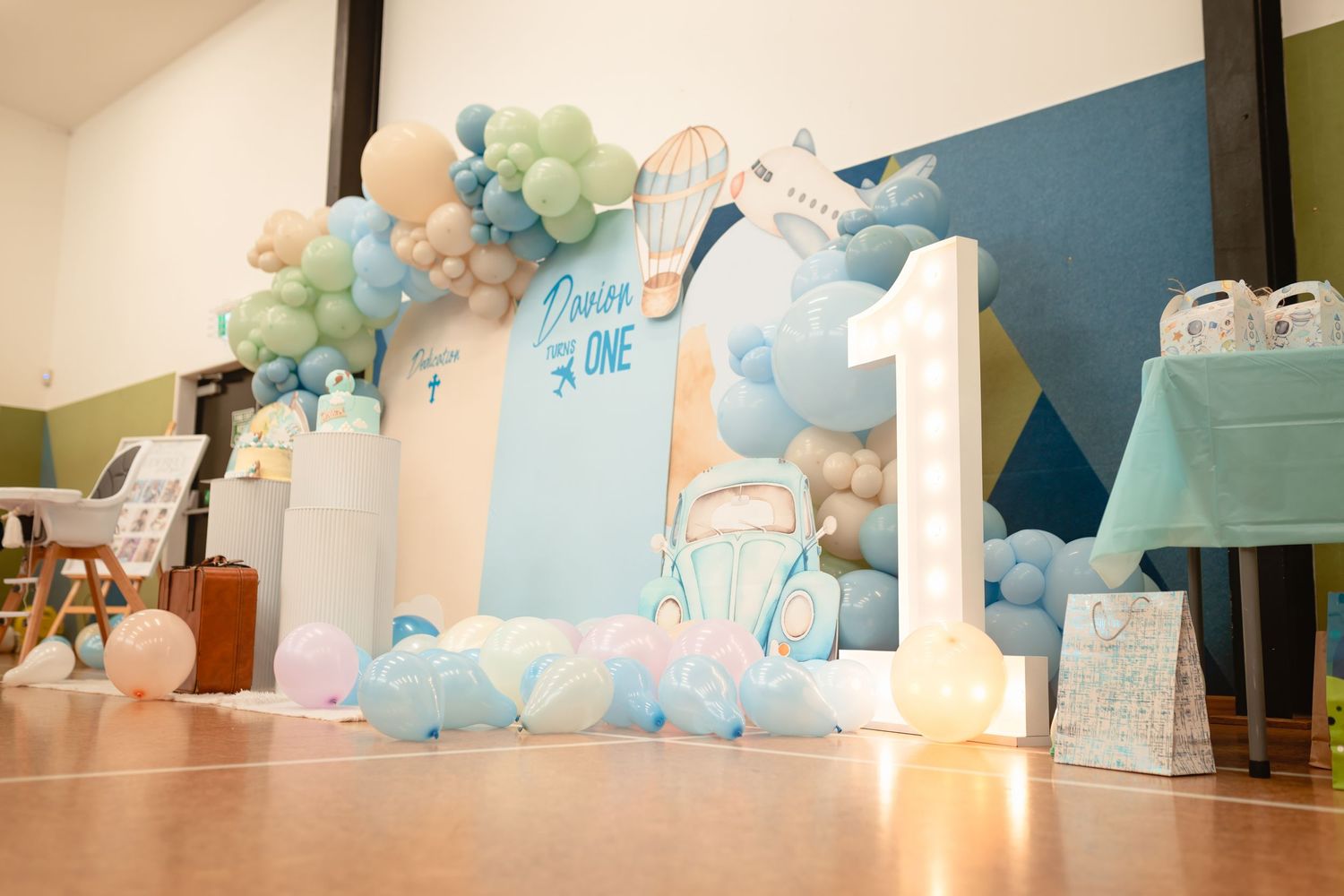 A blue and white themed party setup with balloon arch and travel decorations.