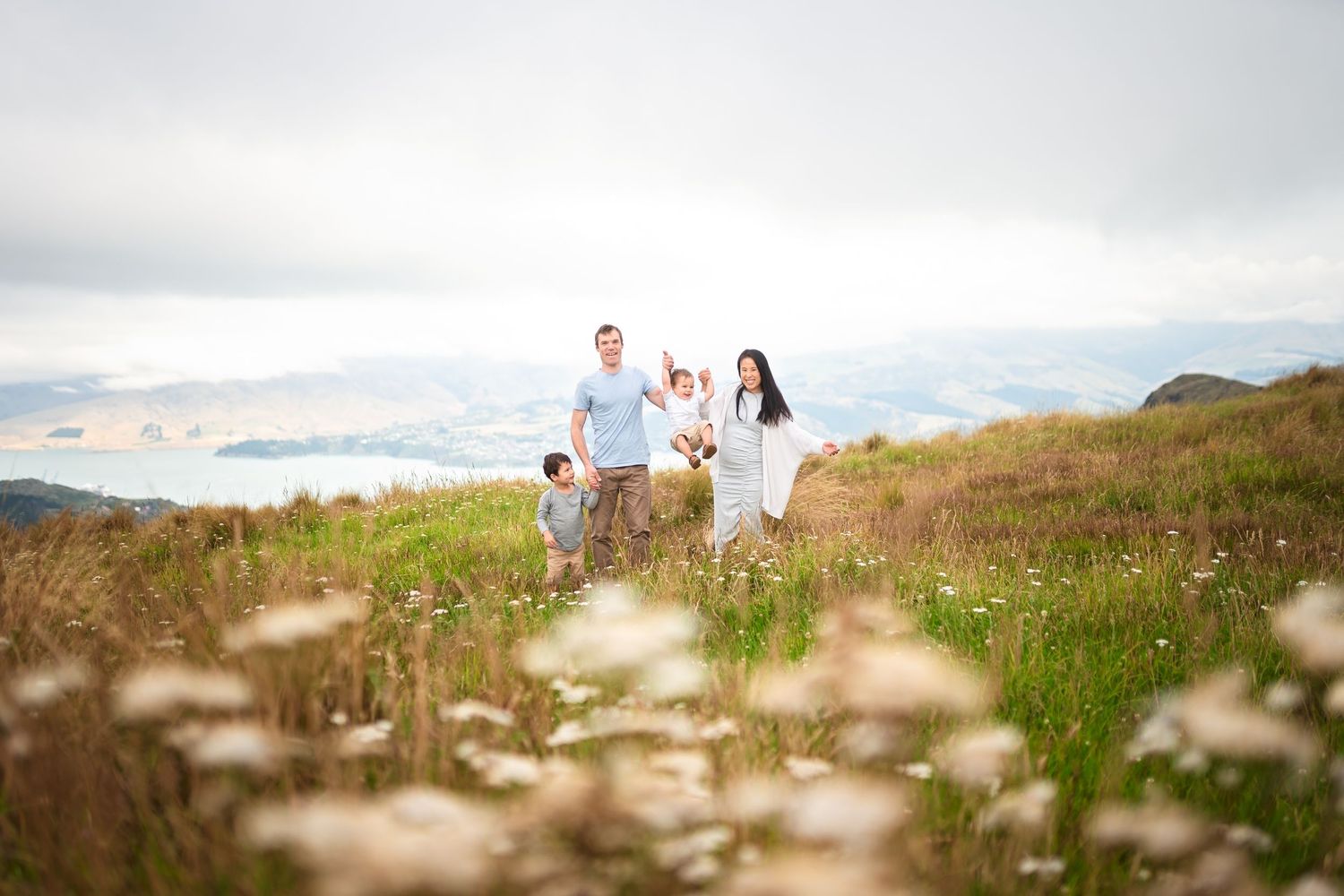 Family walking through wildflower meadow on mountainside.