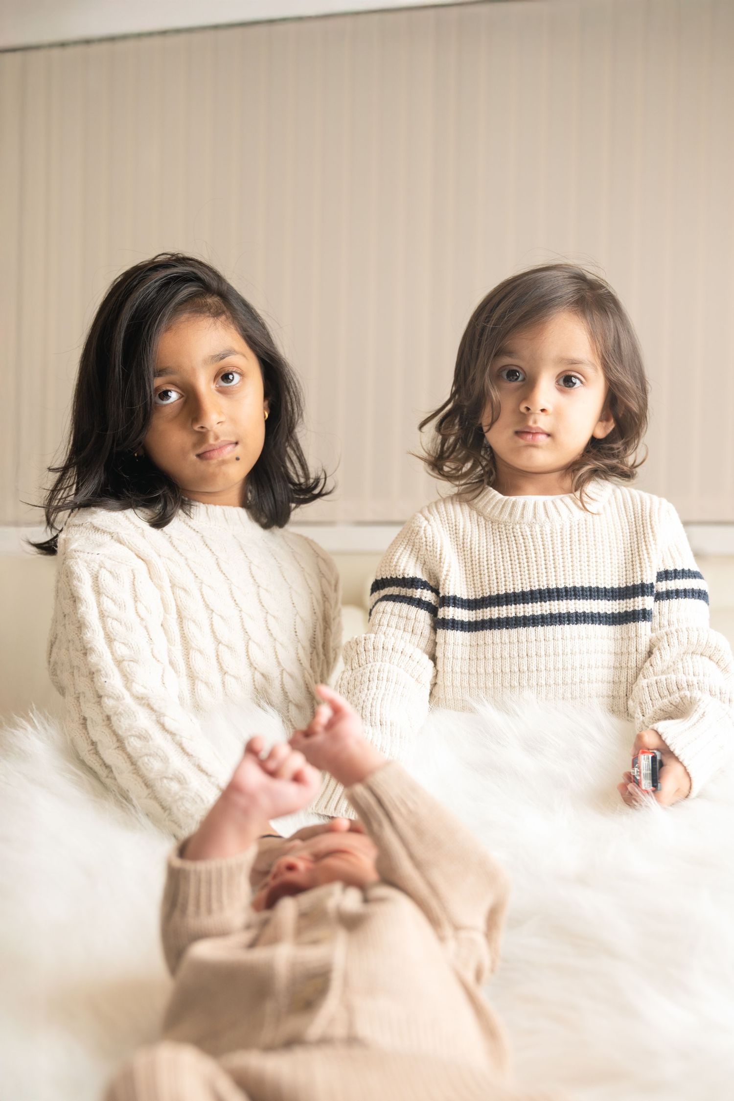 A tender moment between parent and baby wearing a knit sweater.