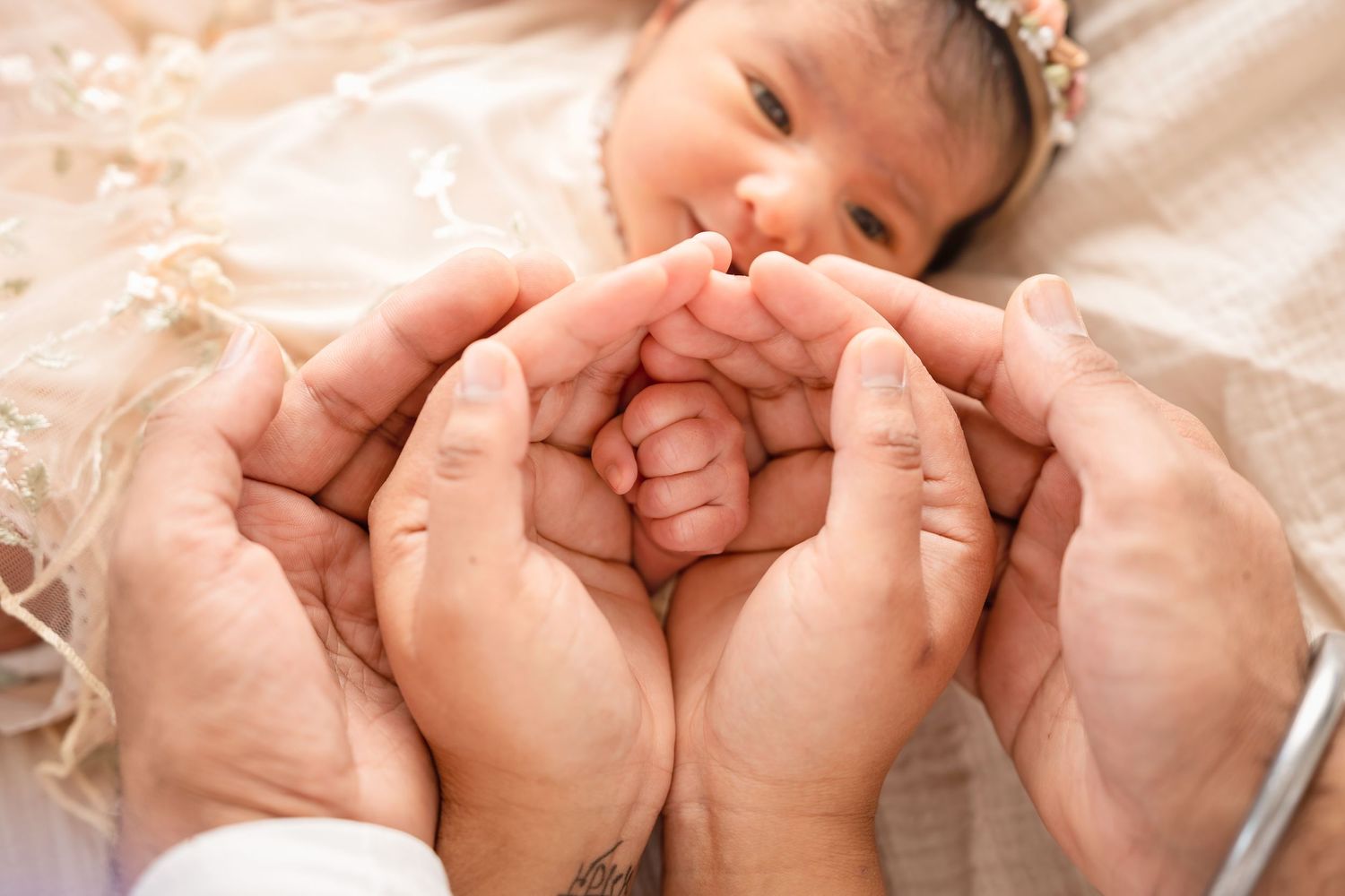 Parents cradling their newborn baby's tiny feet in their hands, a tender family bonding moment.