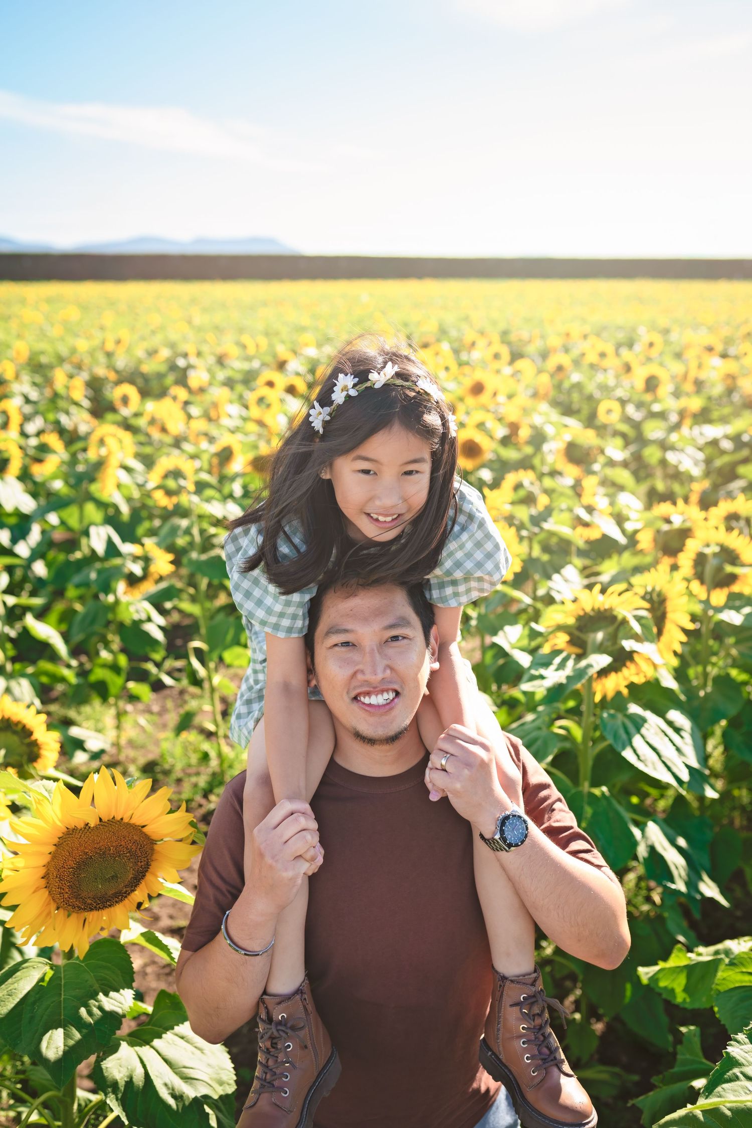 Joyful moment captured in a vibrant sunflower field on a sunny day.