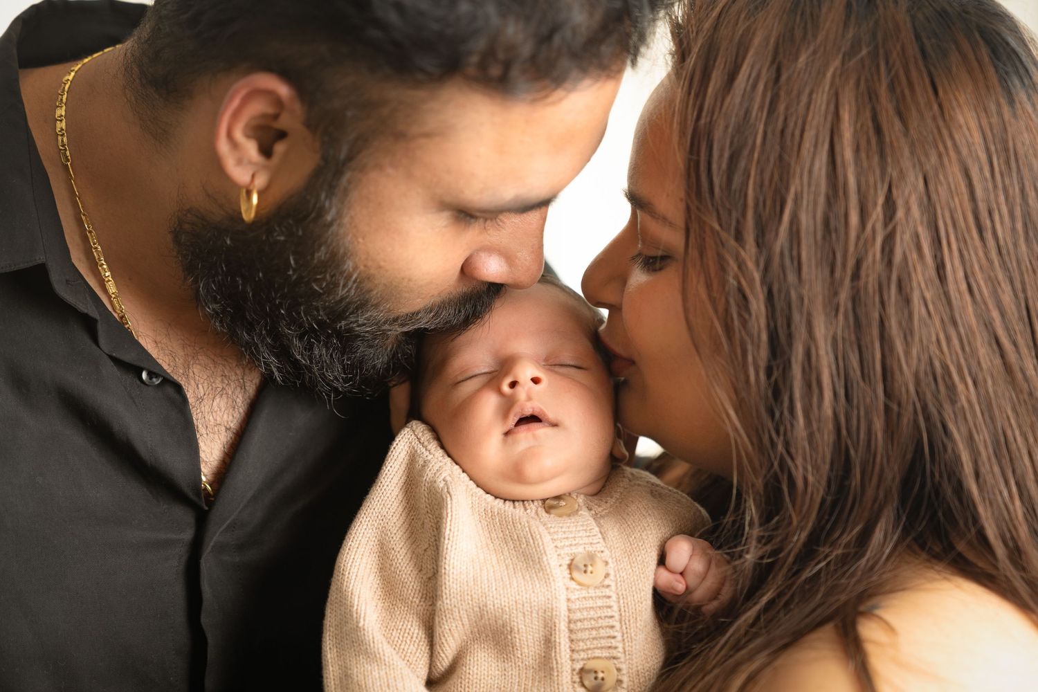Intimate family portrait with baby in beige sweater.
