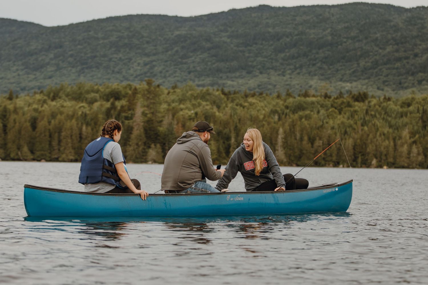 People enjoying a peaceful day canoeing on a lake surrounded by forest.