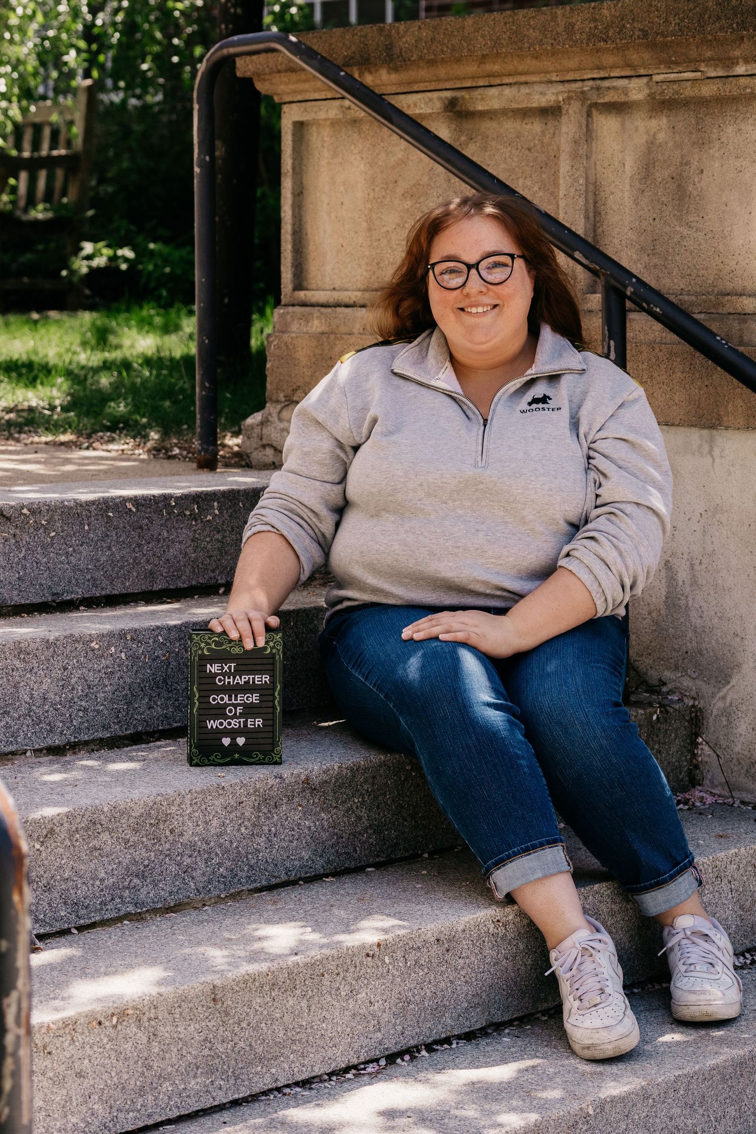 Casual portrait session on concrete steps in natural lighting.