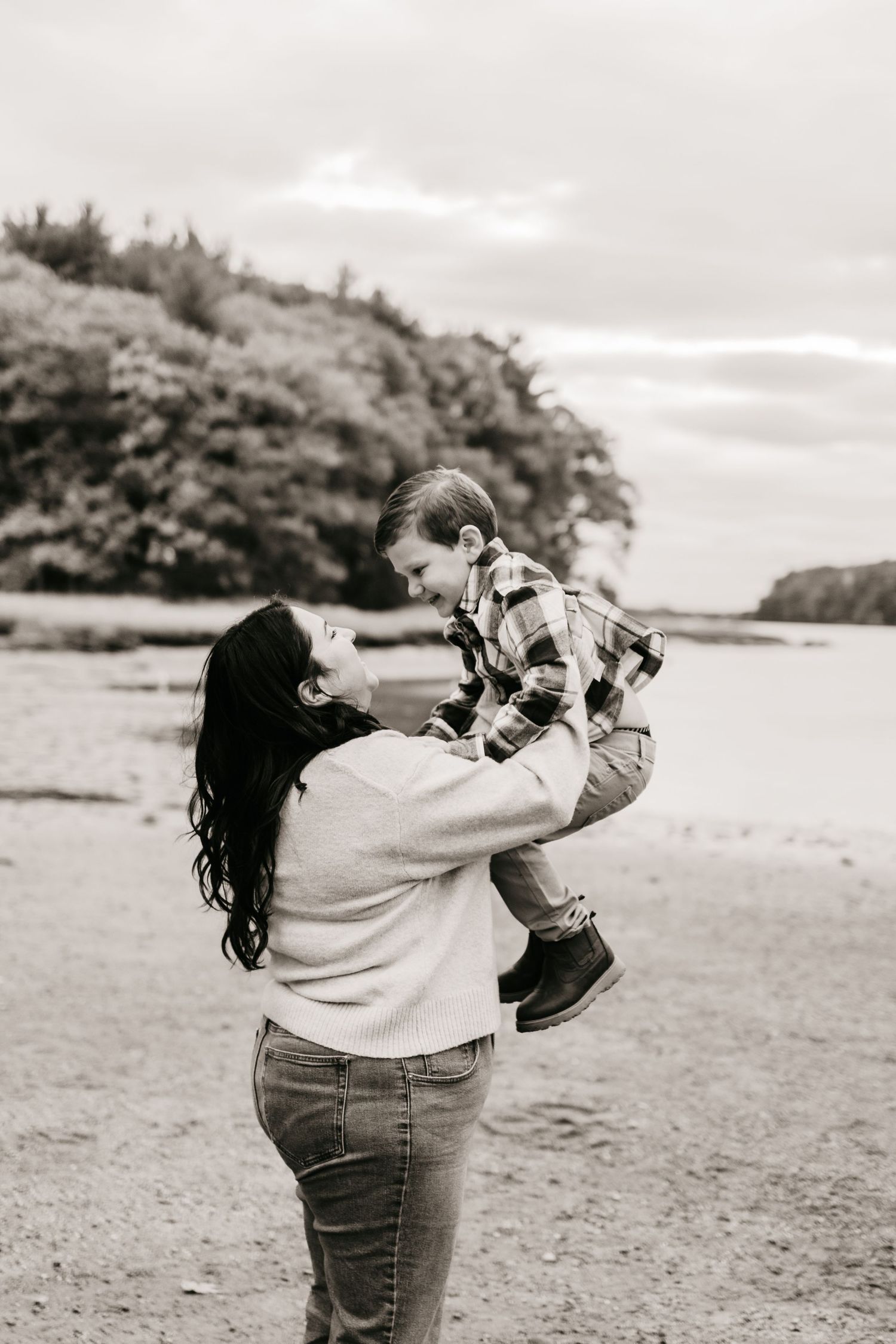 Black and white photo sequence showing joyful moments between parent and child playing on a beach.