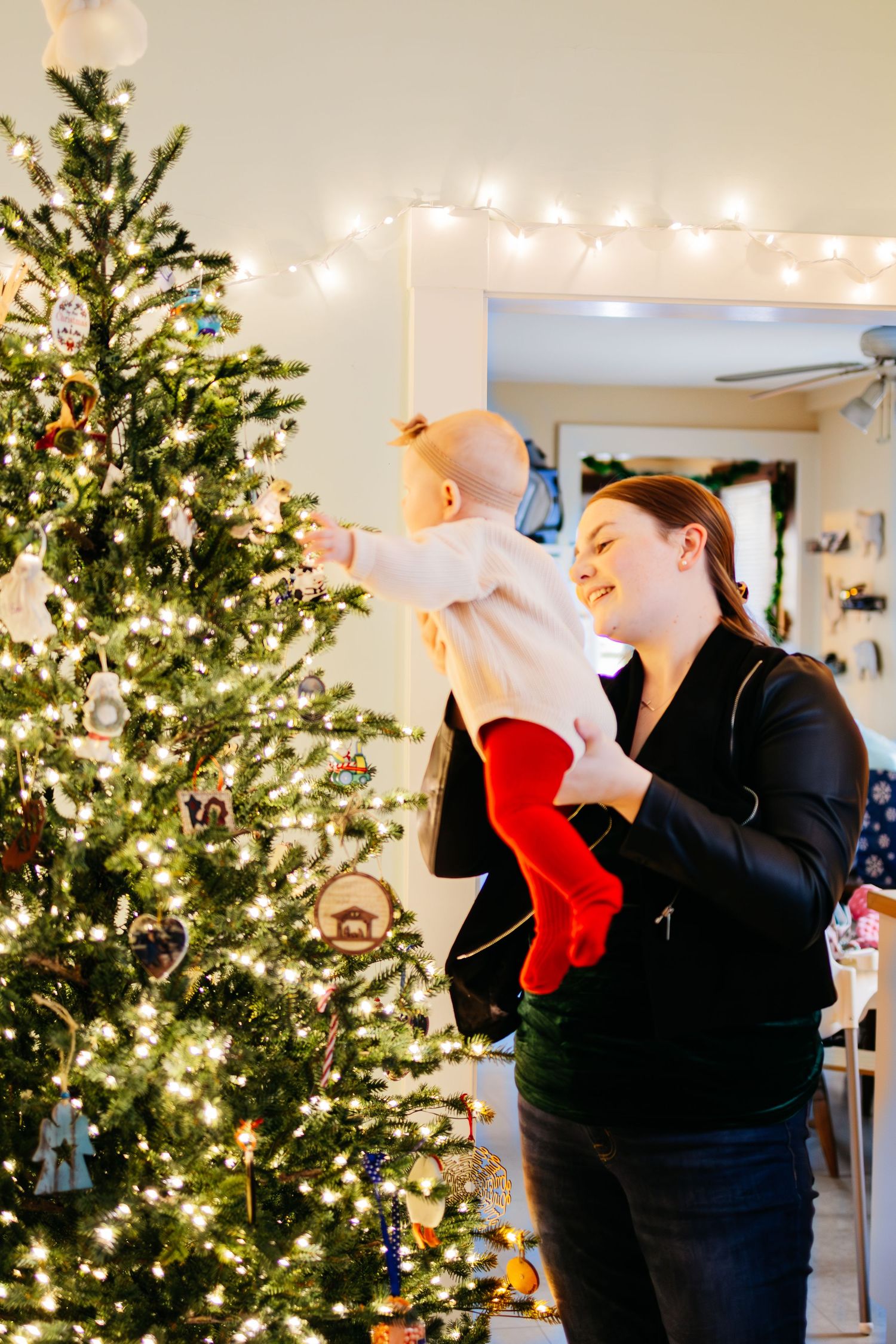 A sequence of photos showing someone peeking inside a Christmas stocking near a decorated tree with twinkling lights.