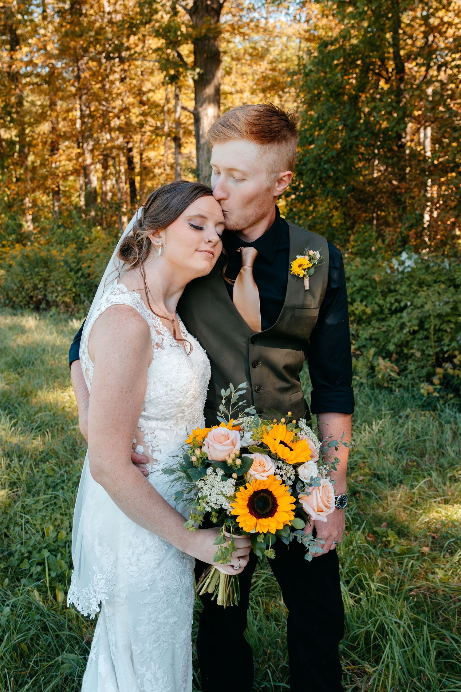 Romantic outdoor wedding portraits with sunflowers and autumn foliage in the background.