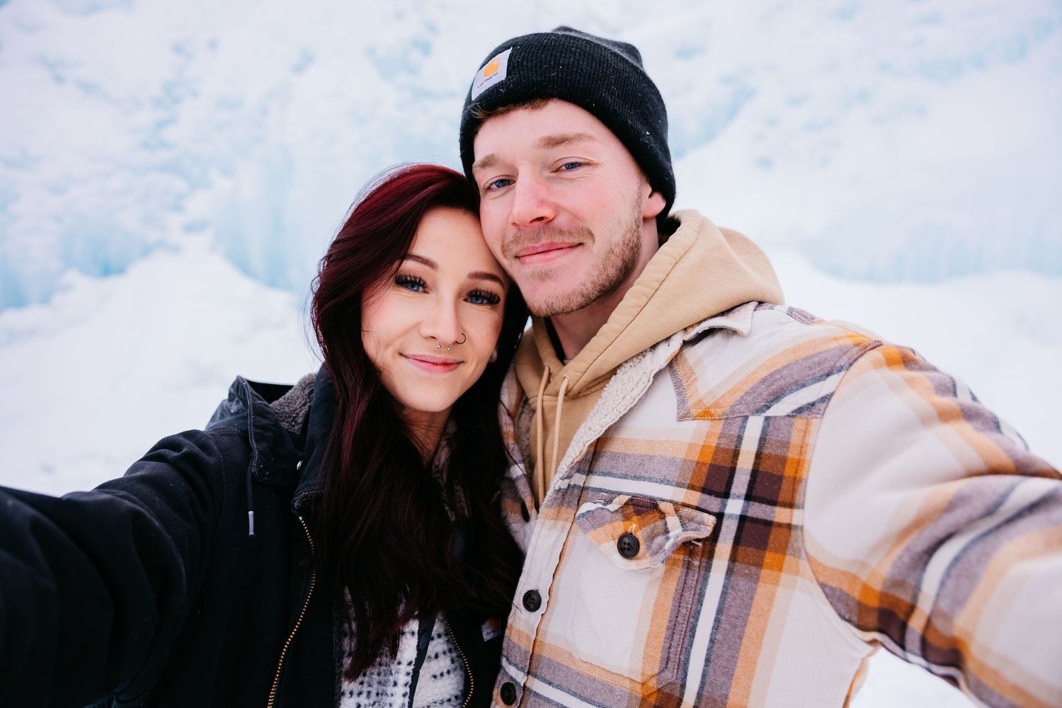 A couple wearing winter hats and scarves share a series of affectionate moments in snowy outdoor settings.