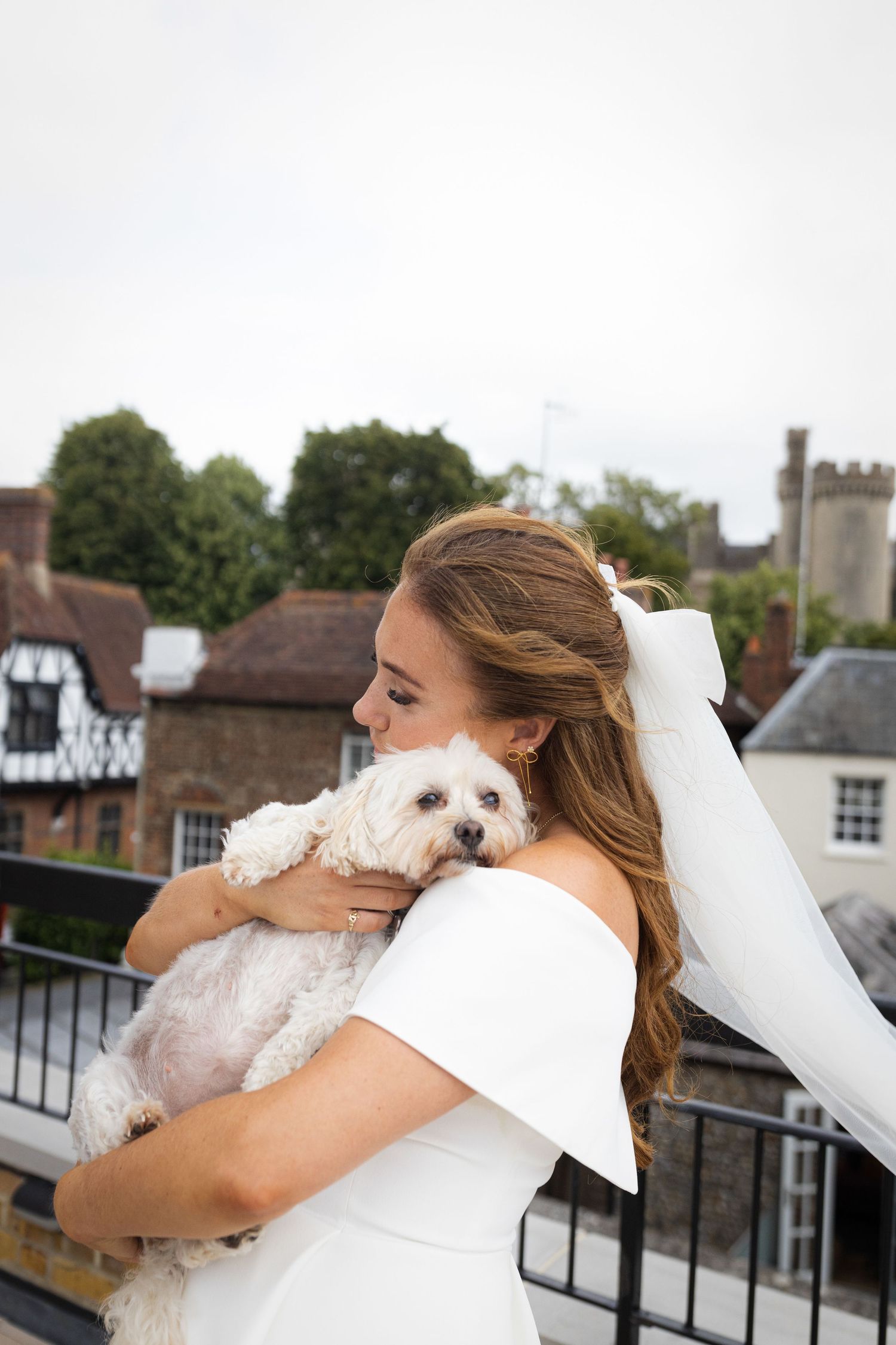 Three sequential photos show a person hugging and cuddling with a small white fluffy dog on an outdoor balcony.