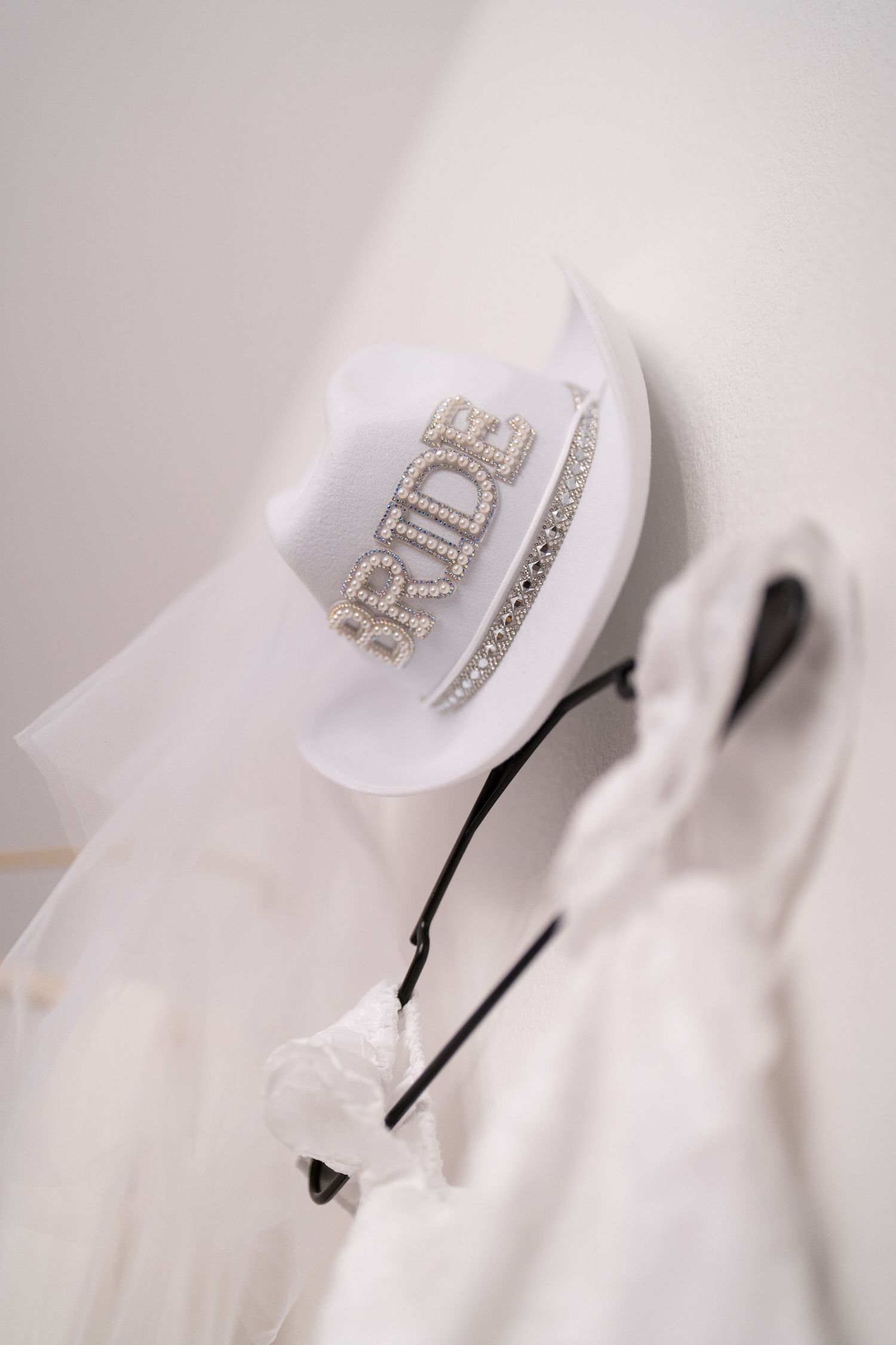 Crystal embellished wedding accessories photographed on white fabric.