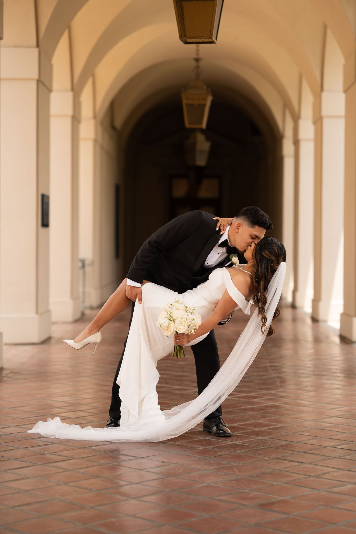 Dramatic dip pose sequence in an elegant colonnade with terra cotta floors.