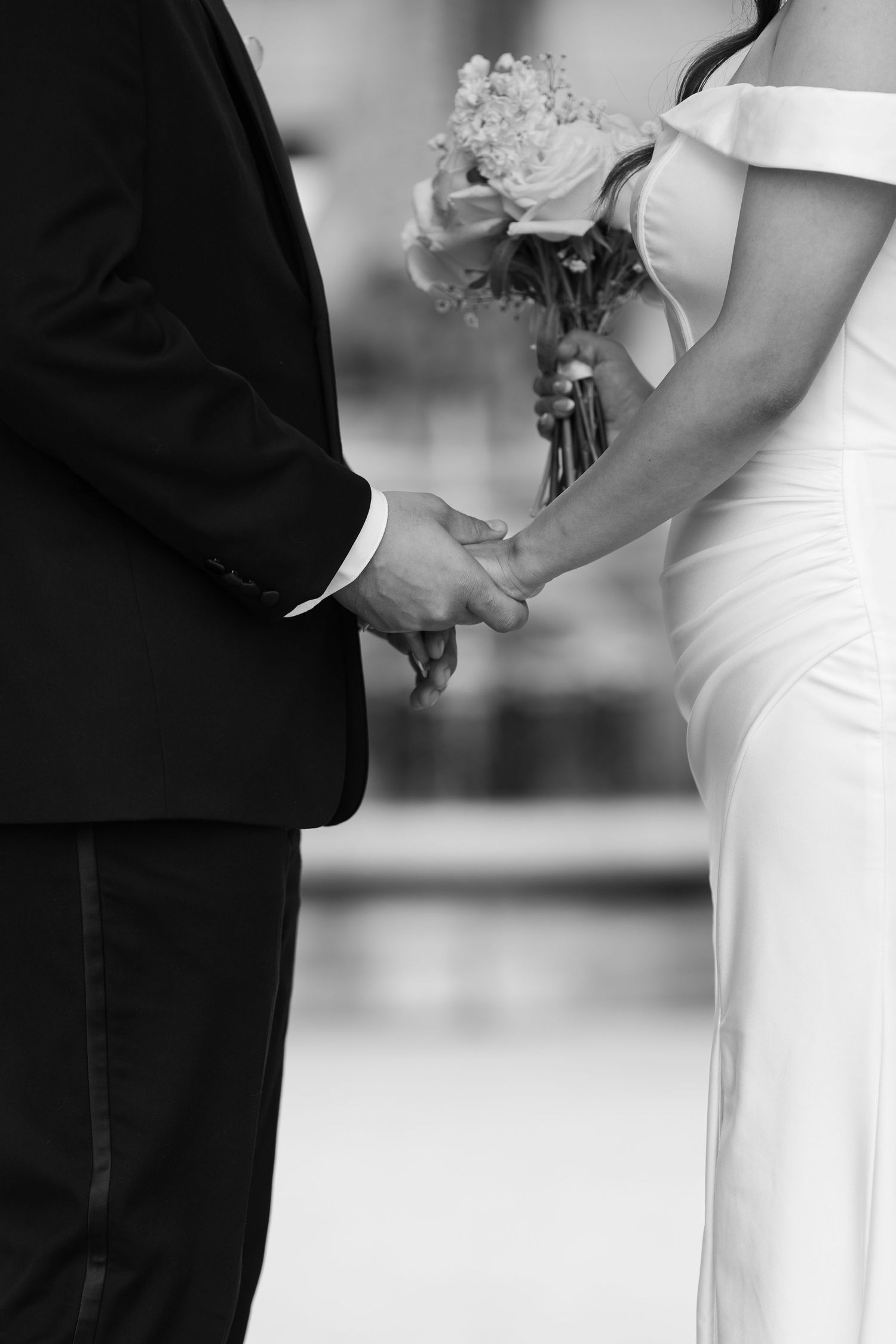 An elegant black and white photograph capturing formal wedding attire details.