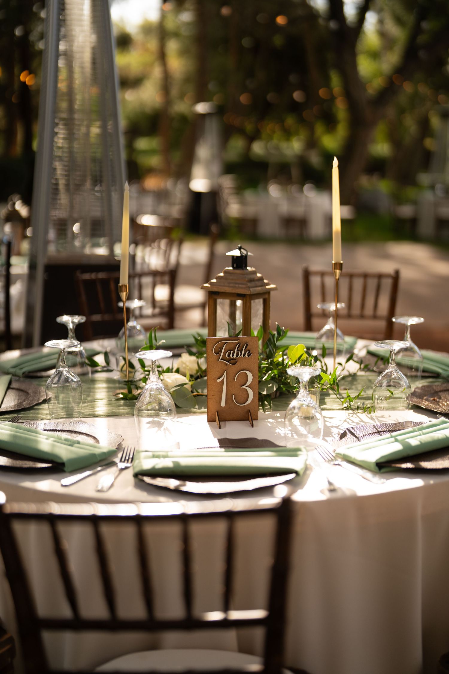 Elegant wedding reception table setting with lantern centerpiece and table number thirteen.