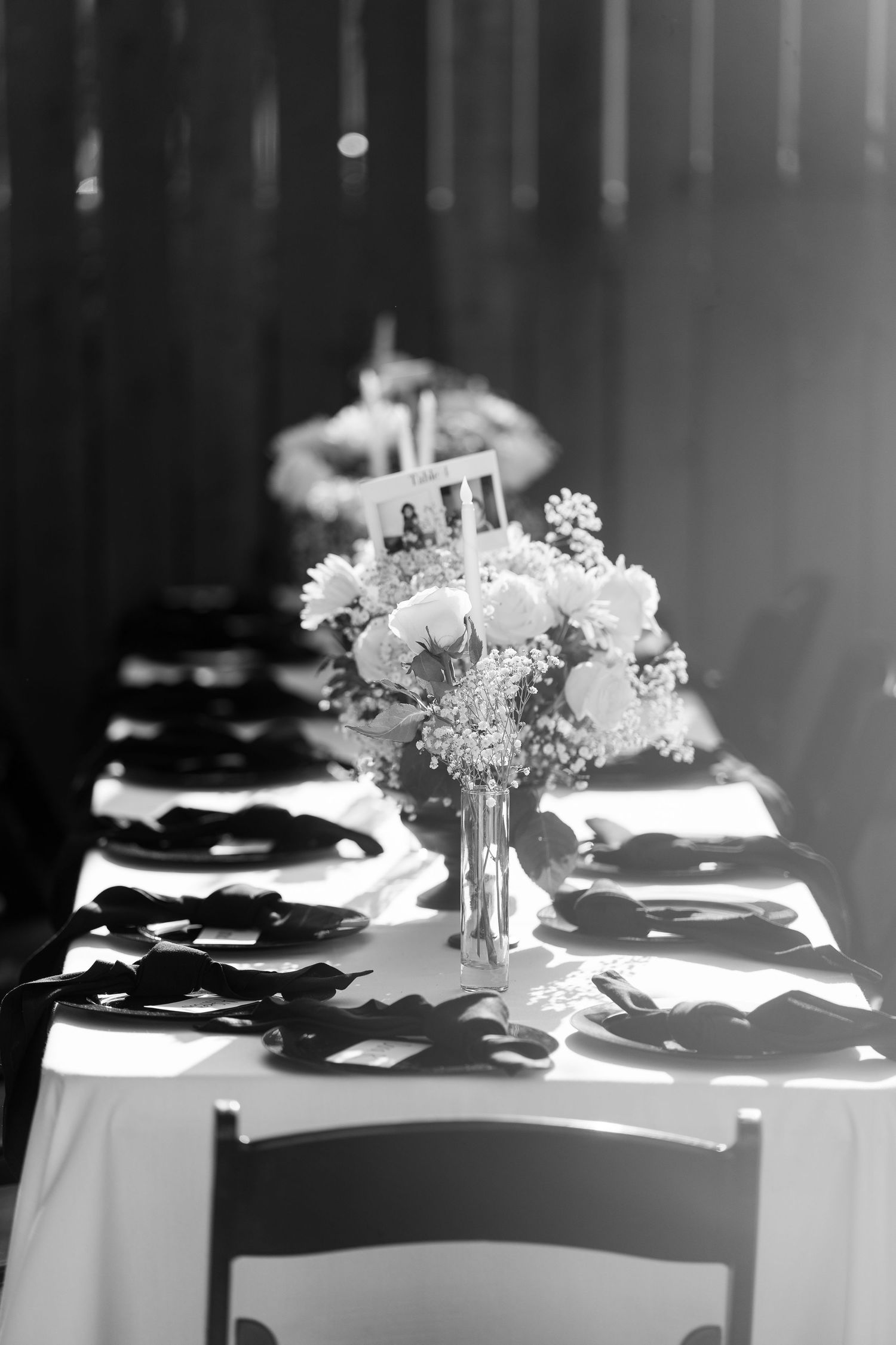 Elegant wedding table settings with floral centerpieces in dramatic black and white.