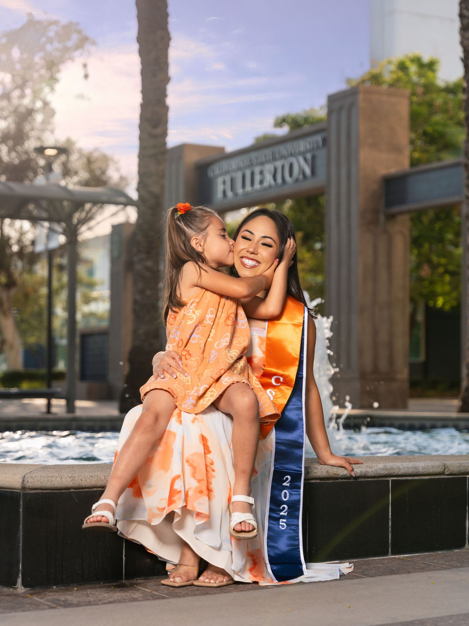 A series of four photos showing someone in an orange floral dress sitting and posing on outdoor stone steps.