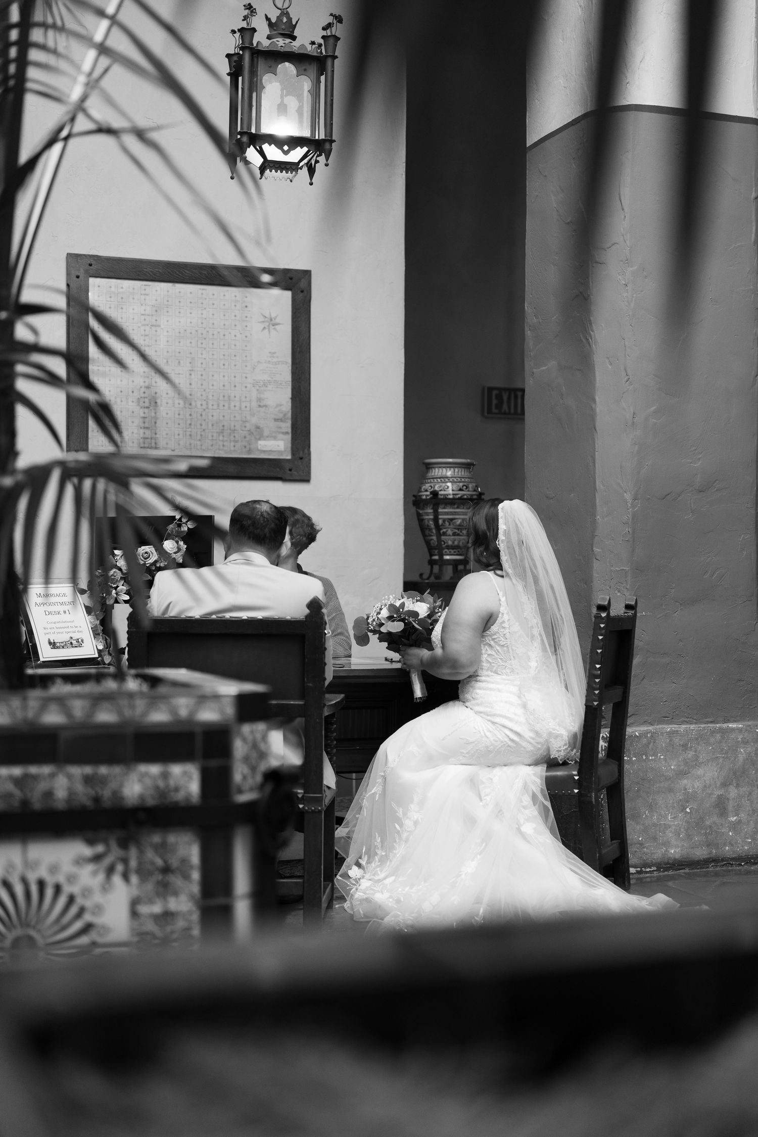Artistic black and white composition of white wedding dress through multiple window frames.