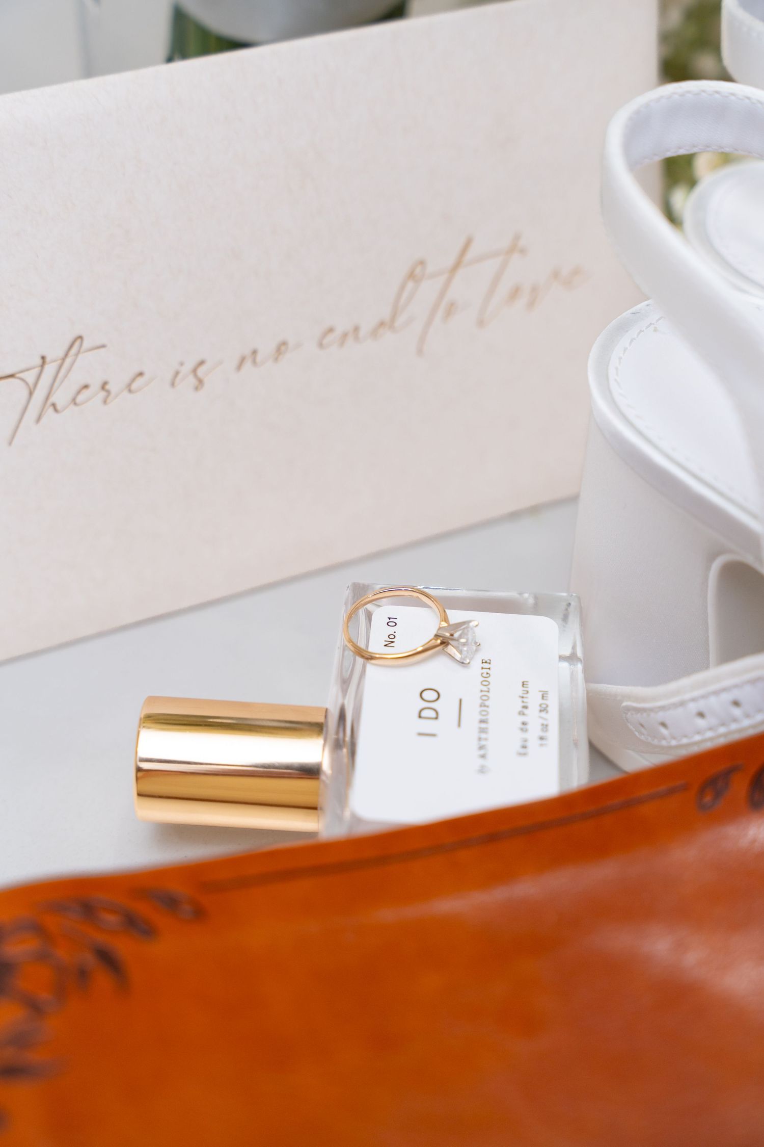 White calligraphy text displayed against a warm wood surface with perfume bottle in soft focus.