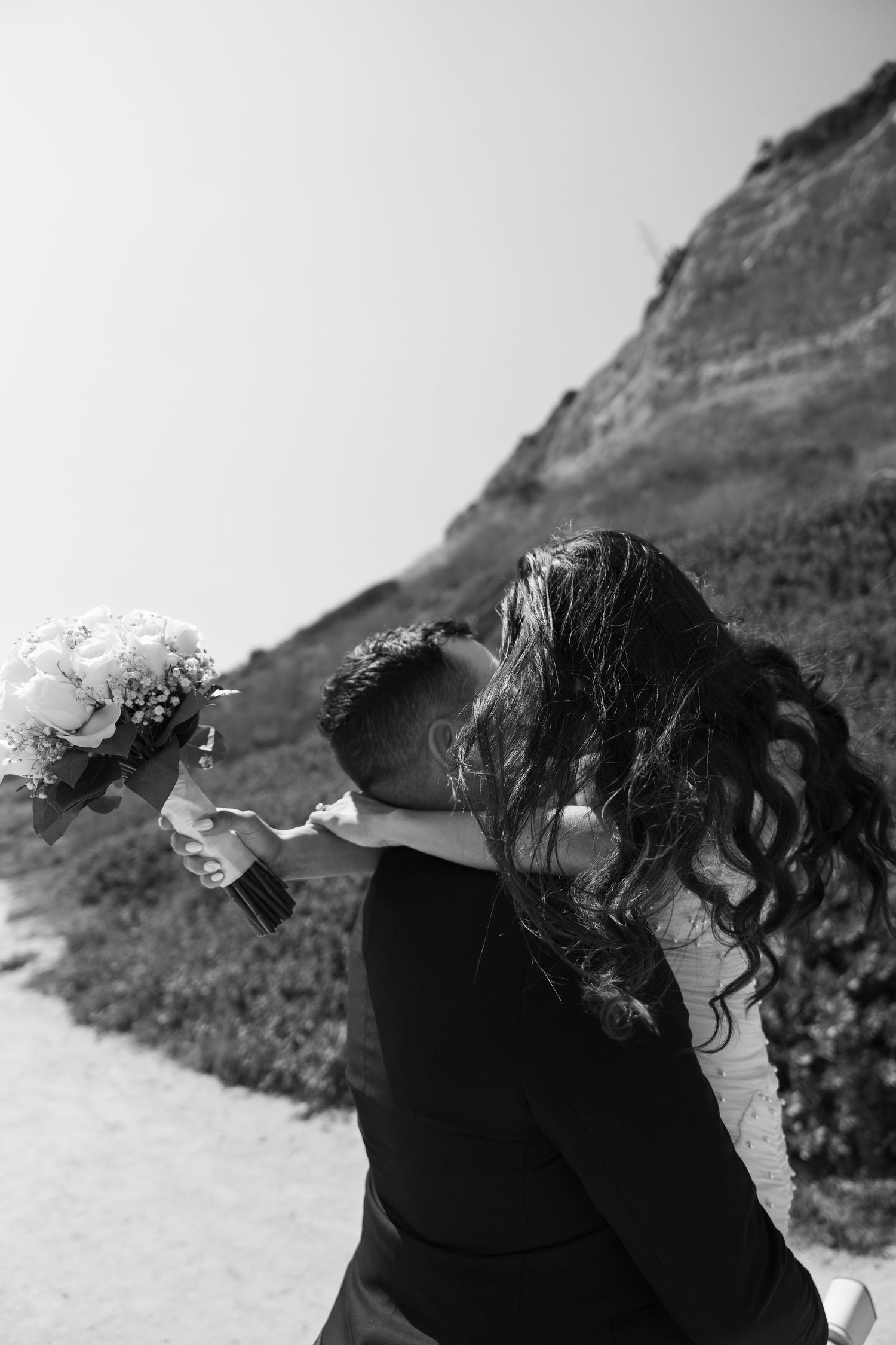 A dramatic black and white coastal portrait with cliffs in the background.