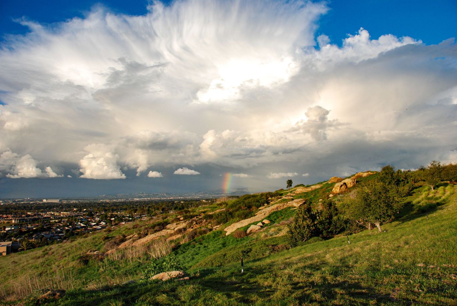 Stunning cloud patterns and a rainbow are part of this sweeping landscape.