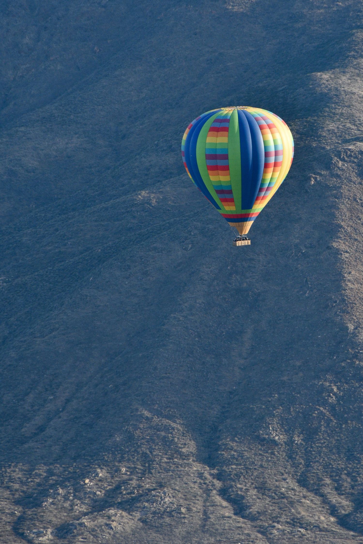 The silent and serene scene of a hot air balloon as seen from another hot air balloon.