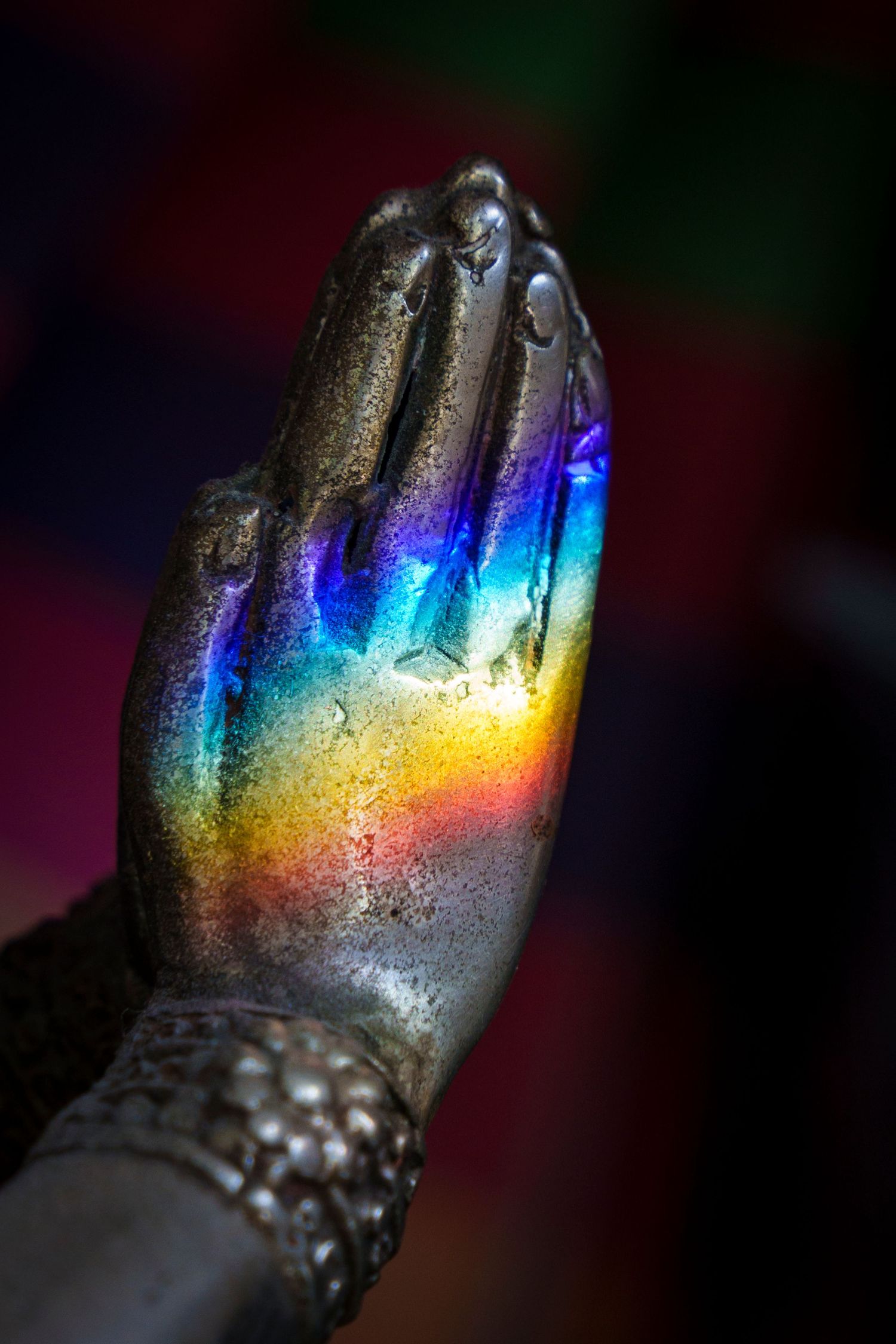 A spectrum is seen on praying hands.  This depicts the many colours of faith.