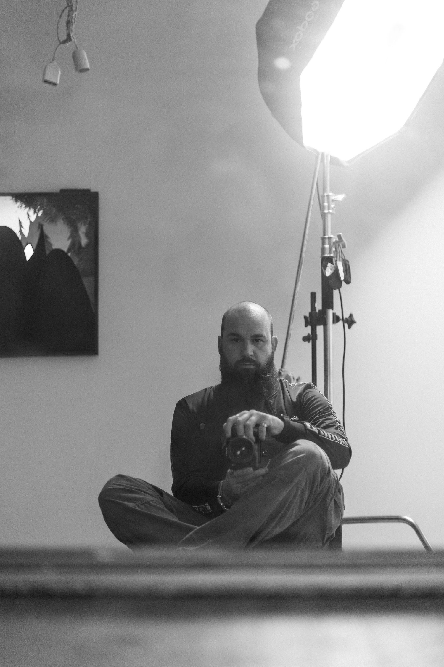 A series of black and white self-portraits taken from a low angle showing a person sitting and reclining on the floor.