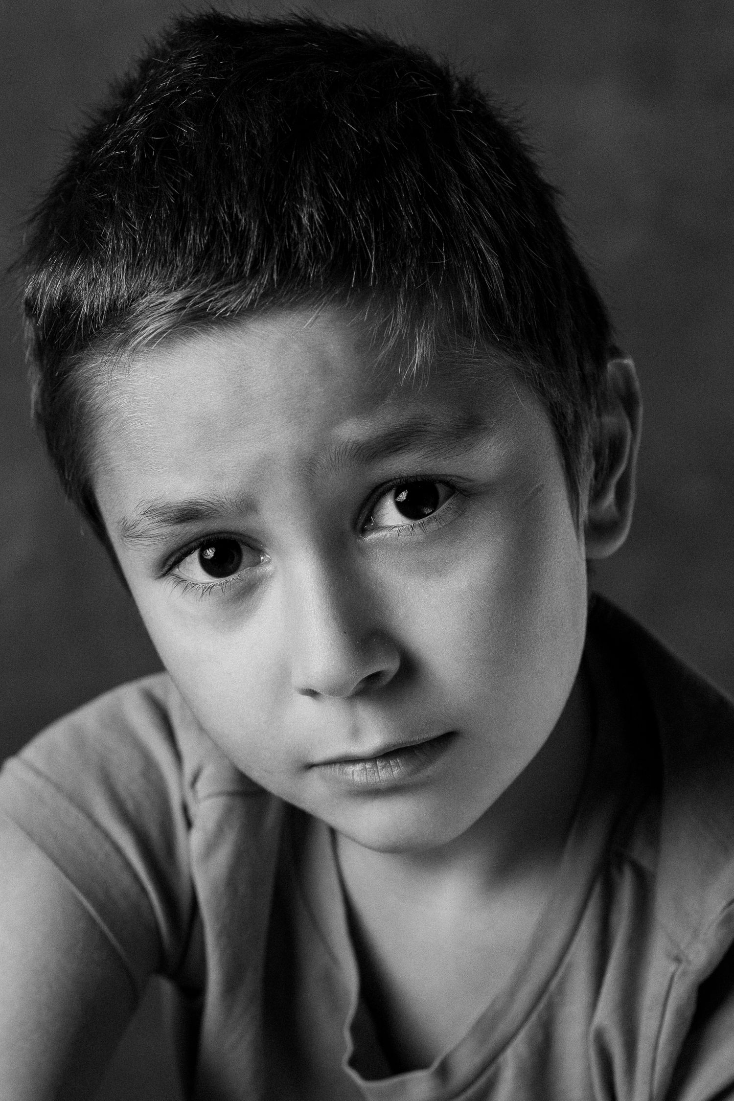 A series of black and white portraits showing different expressions and angles of a young child's face.