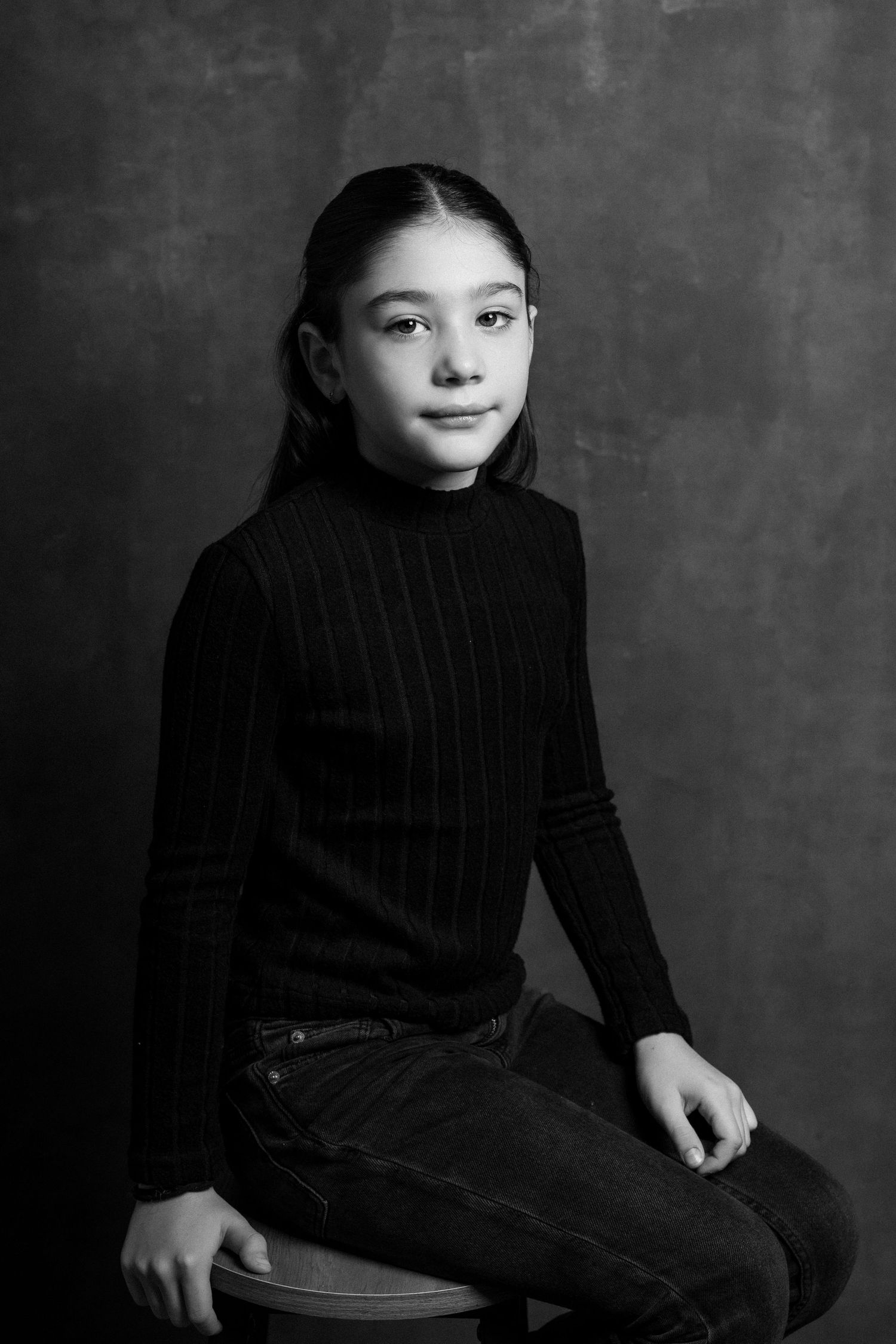Black and white studio portraits showing someone in a black turtleneck against dark background.