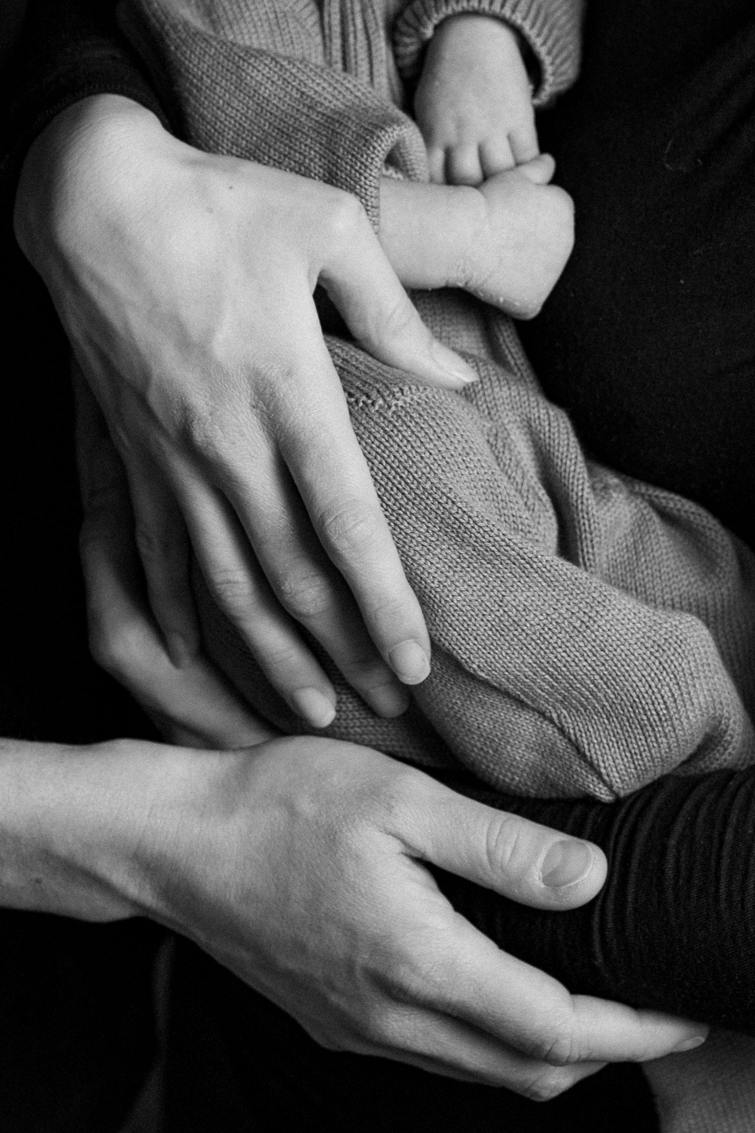 A series of black and white photographs showing hands gently holding and cradling fabric in an intimate artistic style.