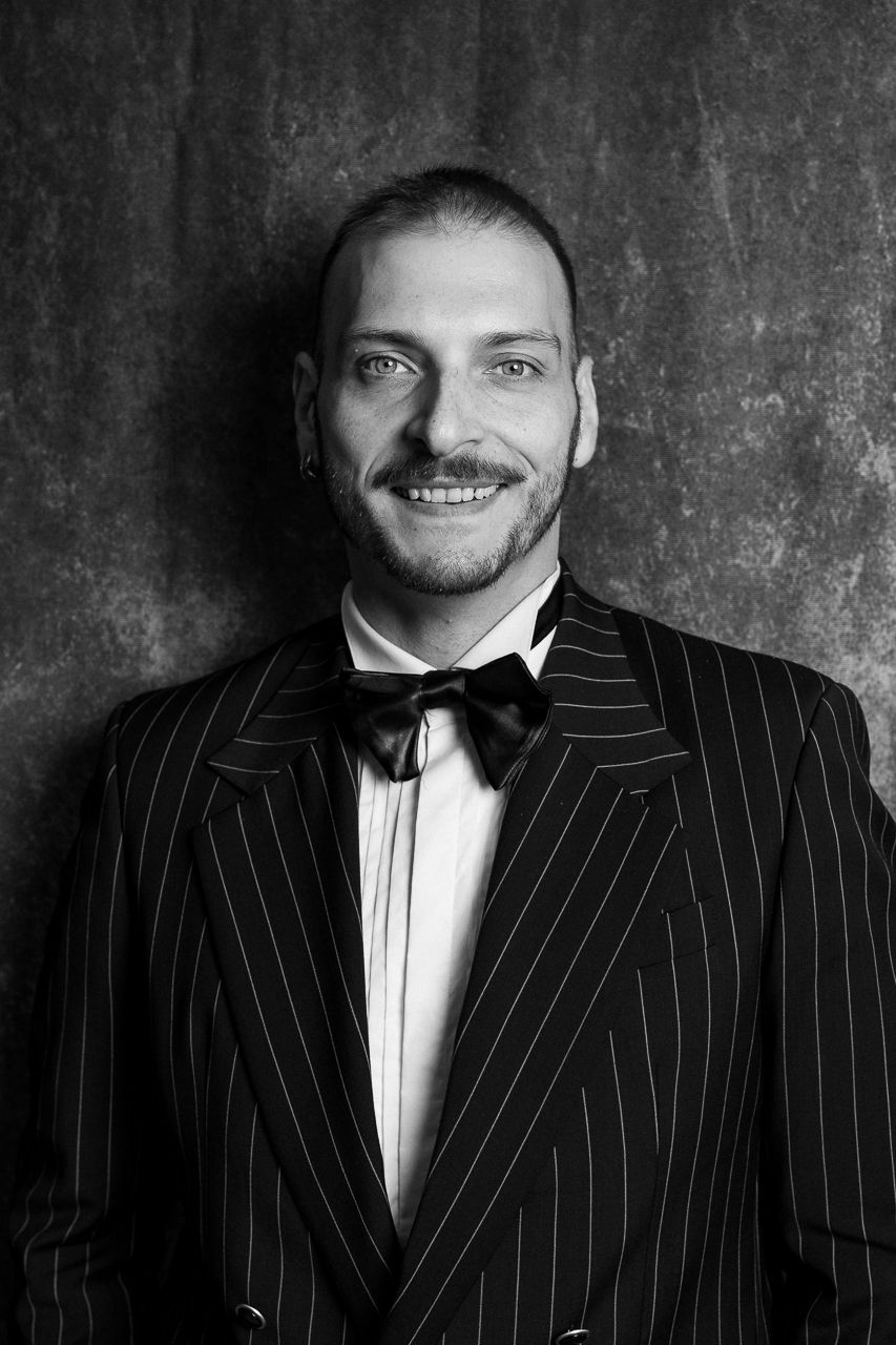 Black and white portrait series of person in pinstripe suit against textured backdrop.