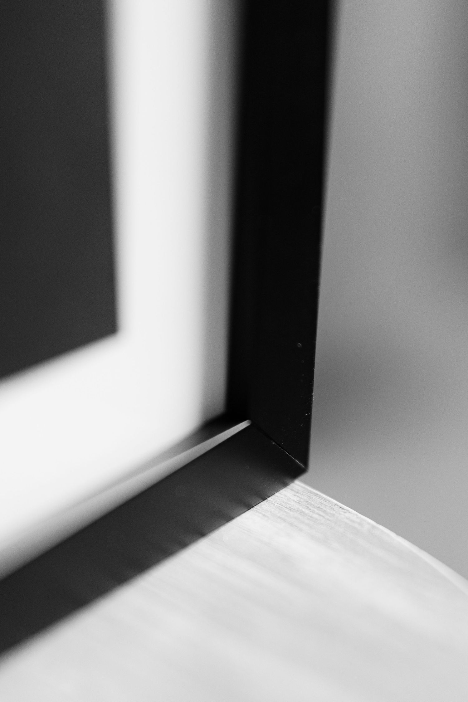 Black and white minimalist architectural detail showing sharp contrast between light and shadow in a corner.
