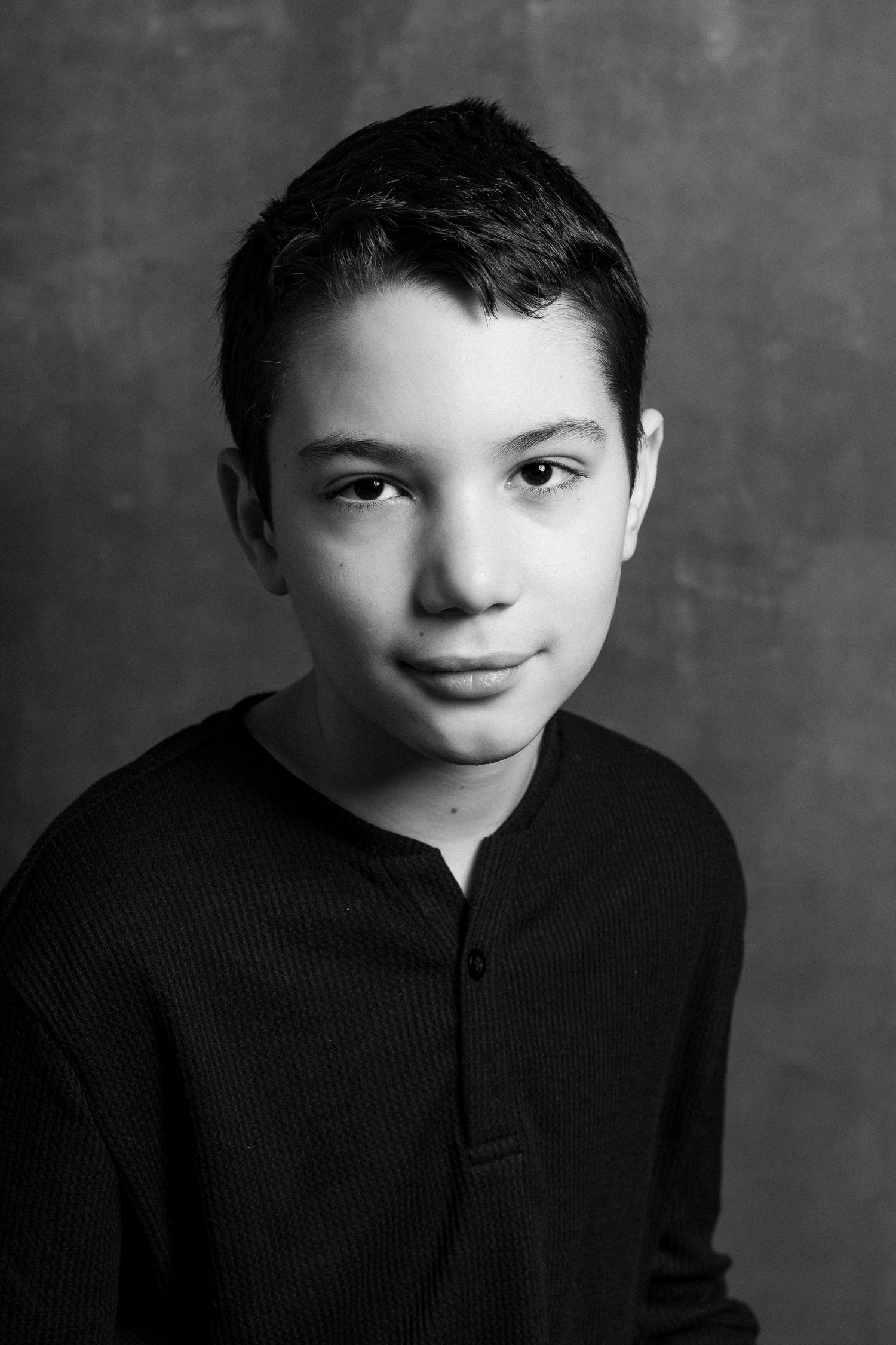 Black and white portrait sequence showing a young figure in dark clothing against a moody backdrop.