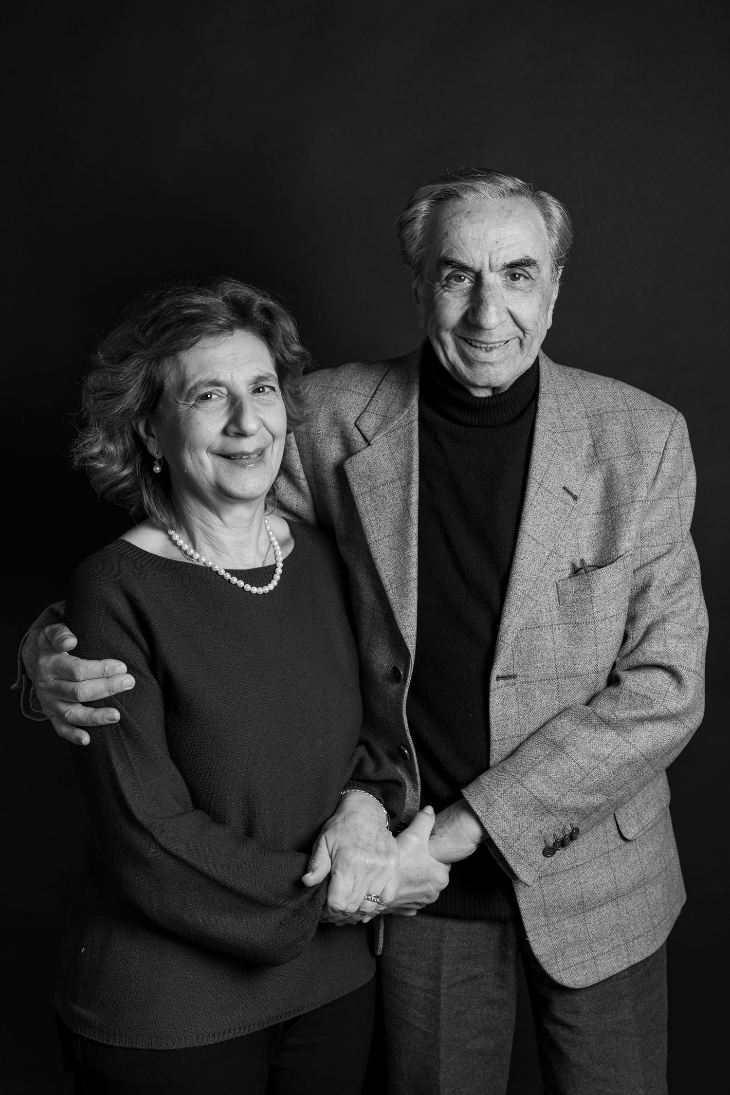 A black and white photo series showing an elderly couple embracing and sharing tender moments together.