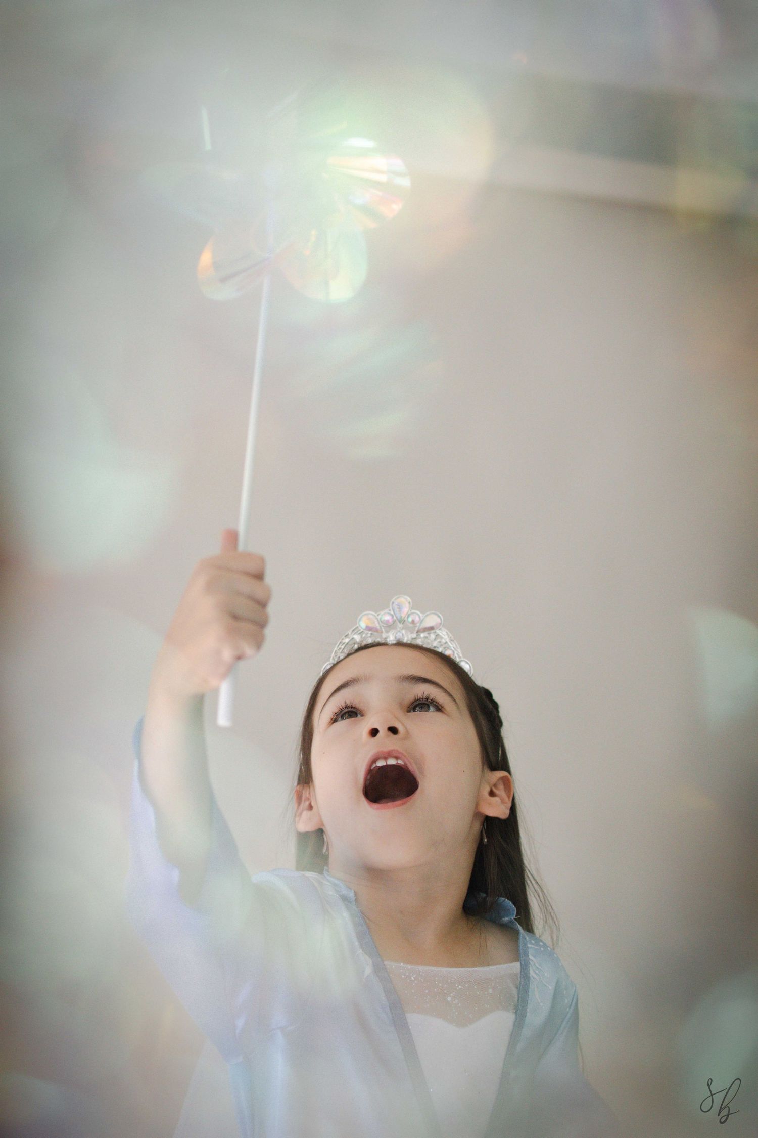 Andover children’s photographer capturing a dreamy personality portrait of a young girl in a blue princess costume and jeweled tiara.
