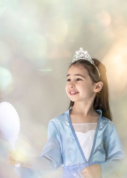 Andover children’s photographer capturing a dreamy personality portrait of a young girl in a blue princess costume and jeweled tiara.