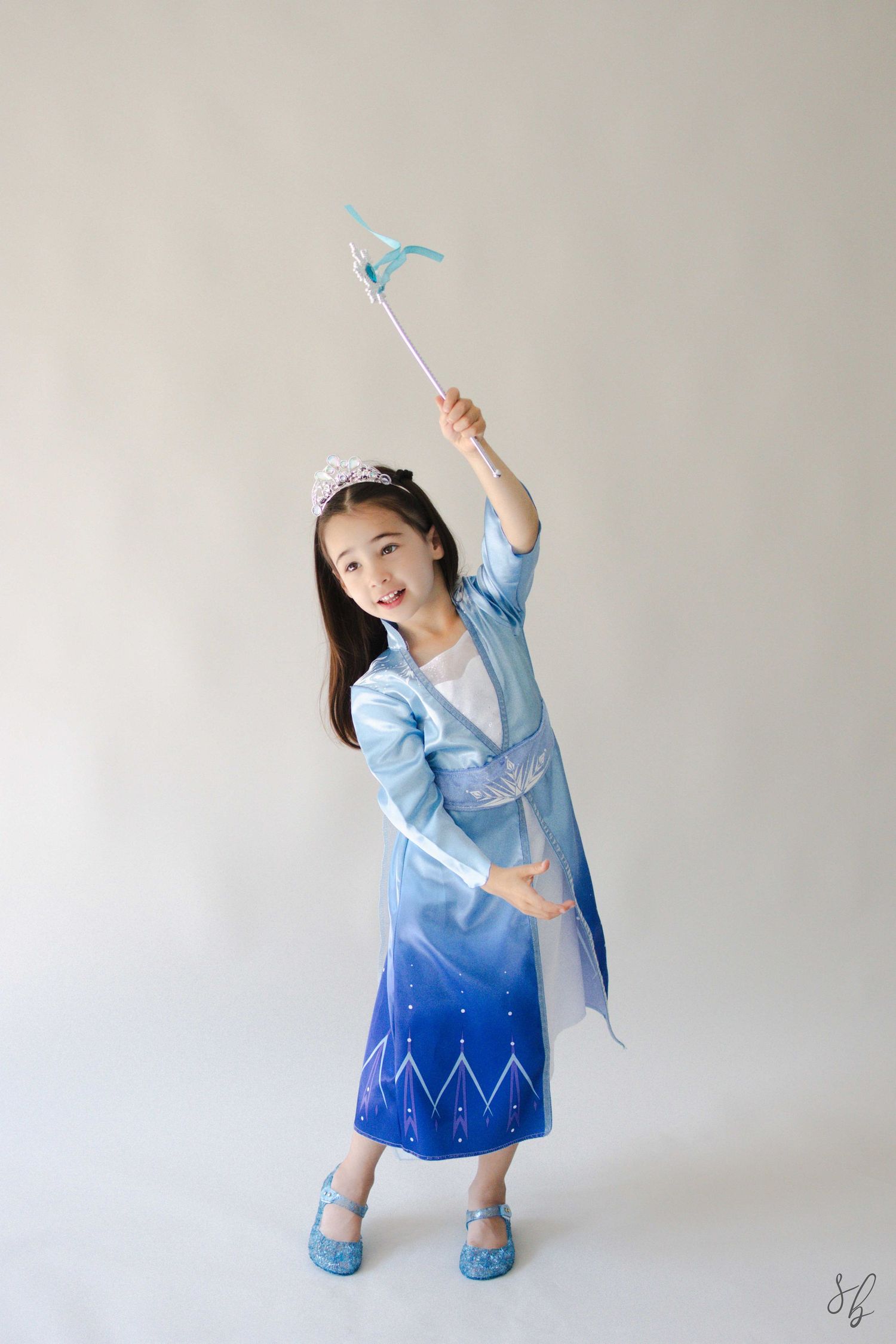 Andover children’s photographer capturing a dreamy personality portrait of a young girl in a blue princess costume and jeweled tiara.