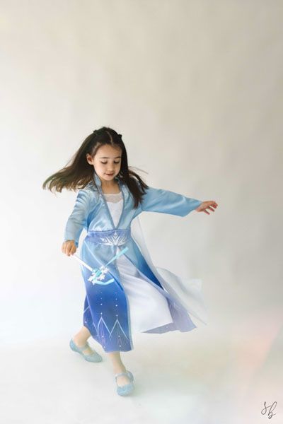 Andover children’s photographer capturing a dreamy personality portrait of a young girl in a blue princess costume and jeweled tiara.