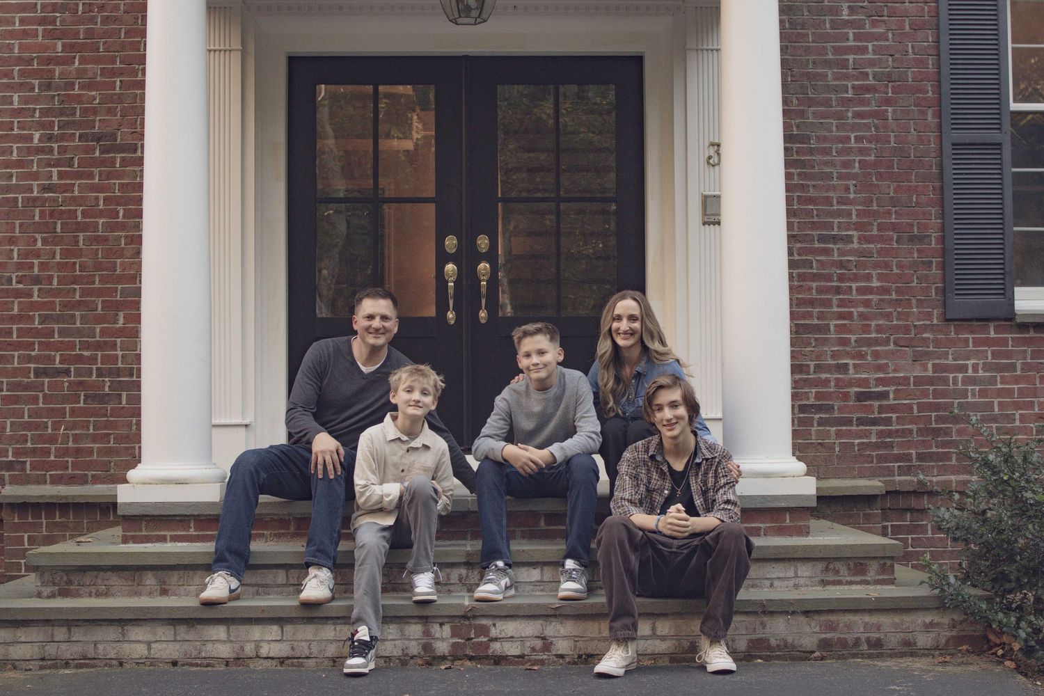 Fall family session in Andover featuring parents embracing their children during a warm, natural outdoor portrait.