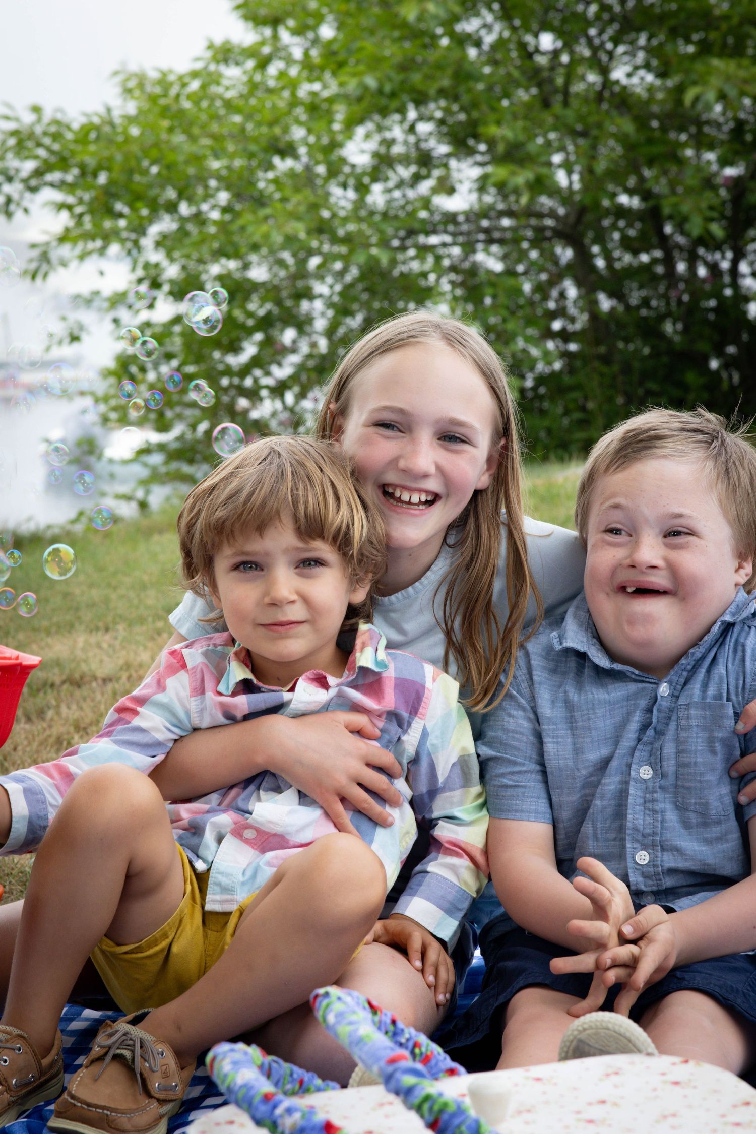 Kids posing for a photo in a picnic setting at Tucks Point in Manchester-by-the-sea.