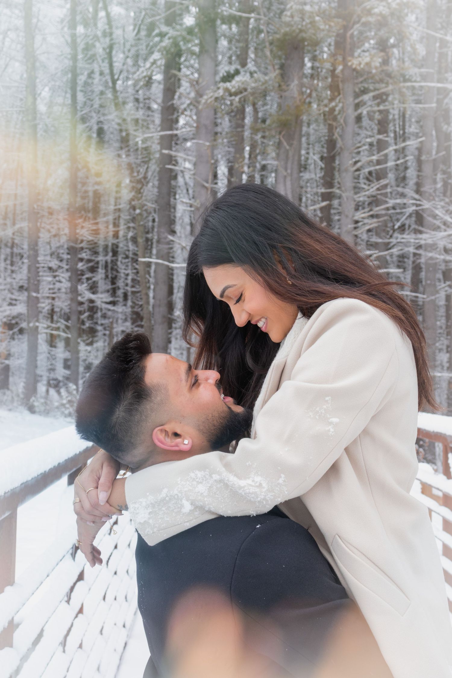 Andover couple photographer capturing a romantic winter session of a couple holding hands and walking through falling snow.