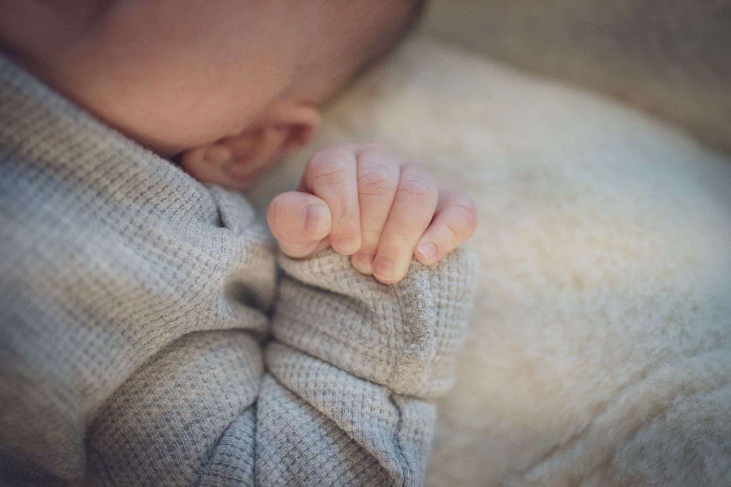 Close‑up newborn detail photo of tiny hands and feet captured by an Andover newborn photographer.