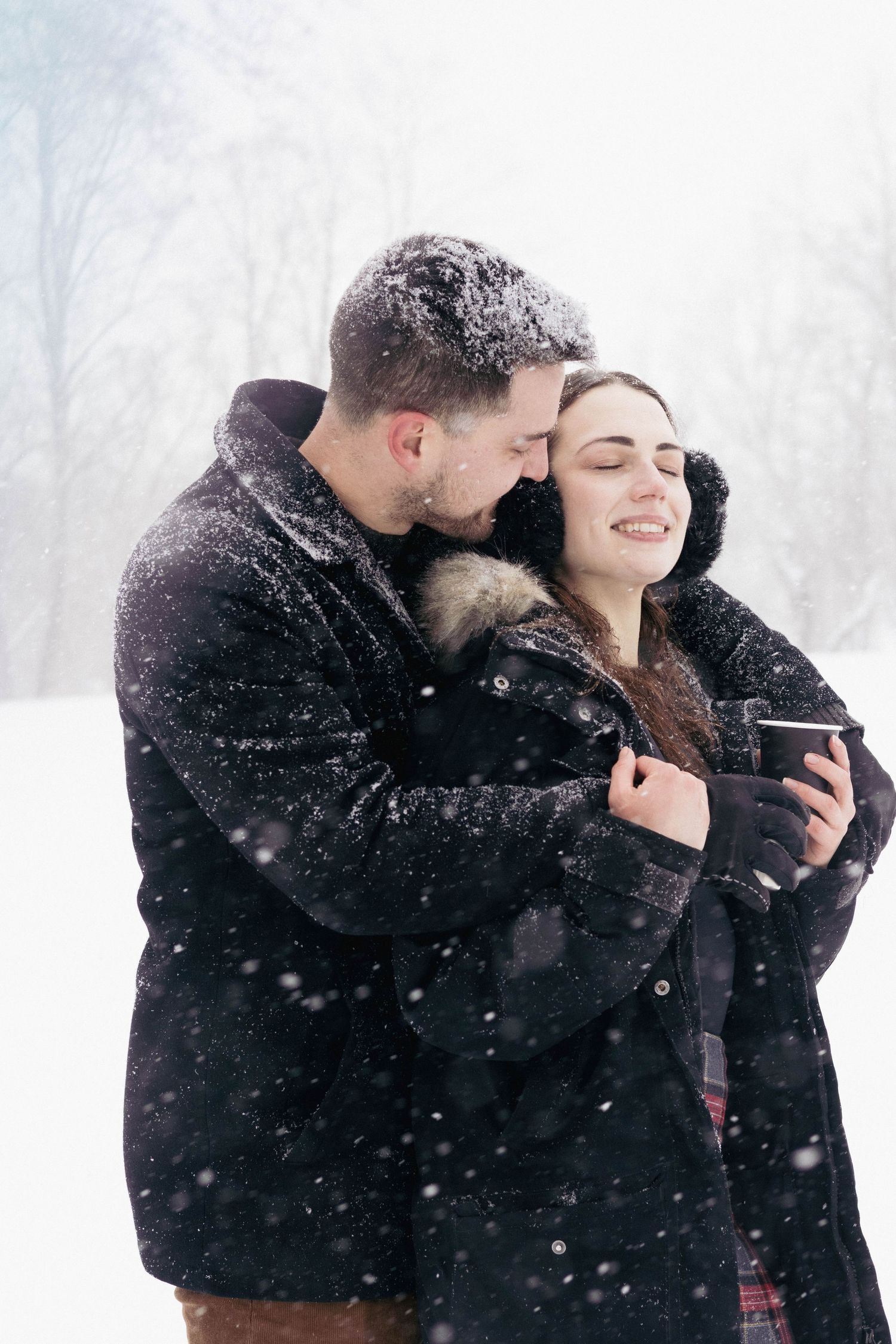 Andover couple photographer capturing a romantic winter session of a couple holding hands and walking through falling snow.