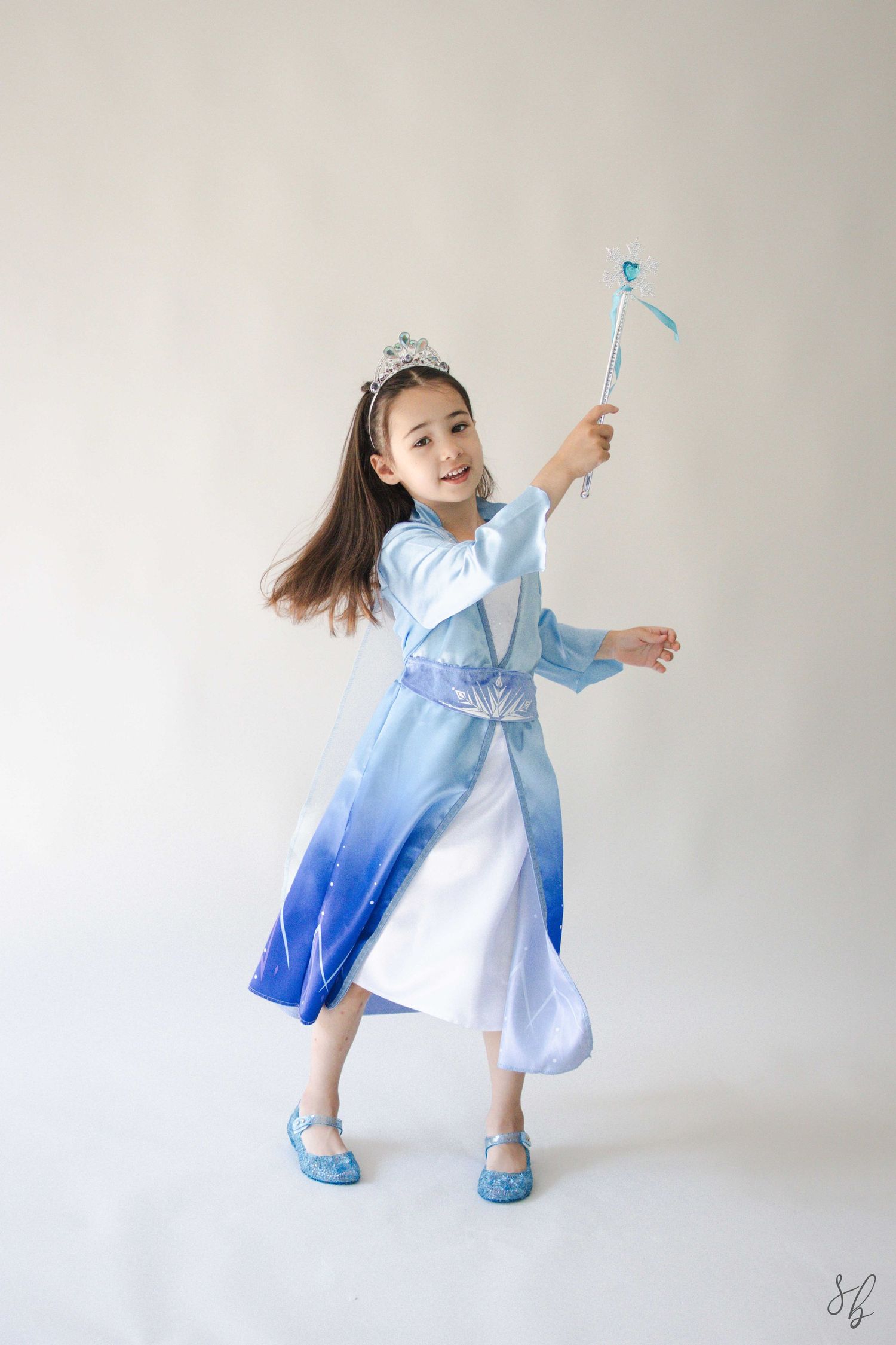 Andover children’s photographer capturing a dreamy personality portrait of a young girl in a blue princess costume and jeweled tiara.