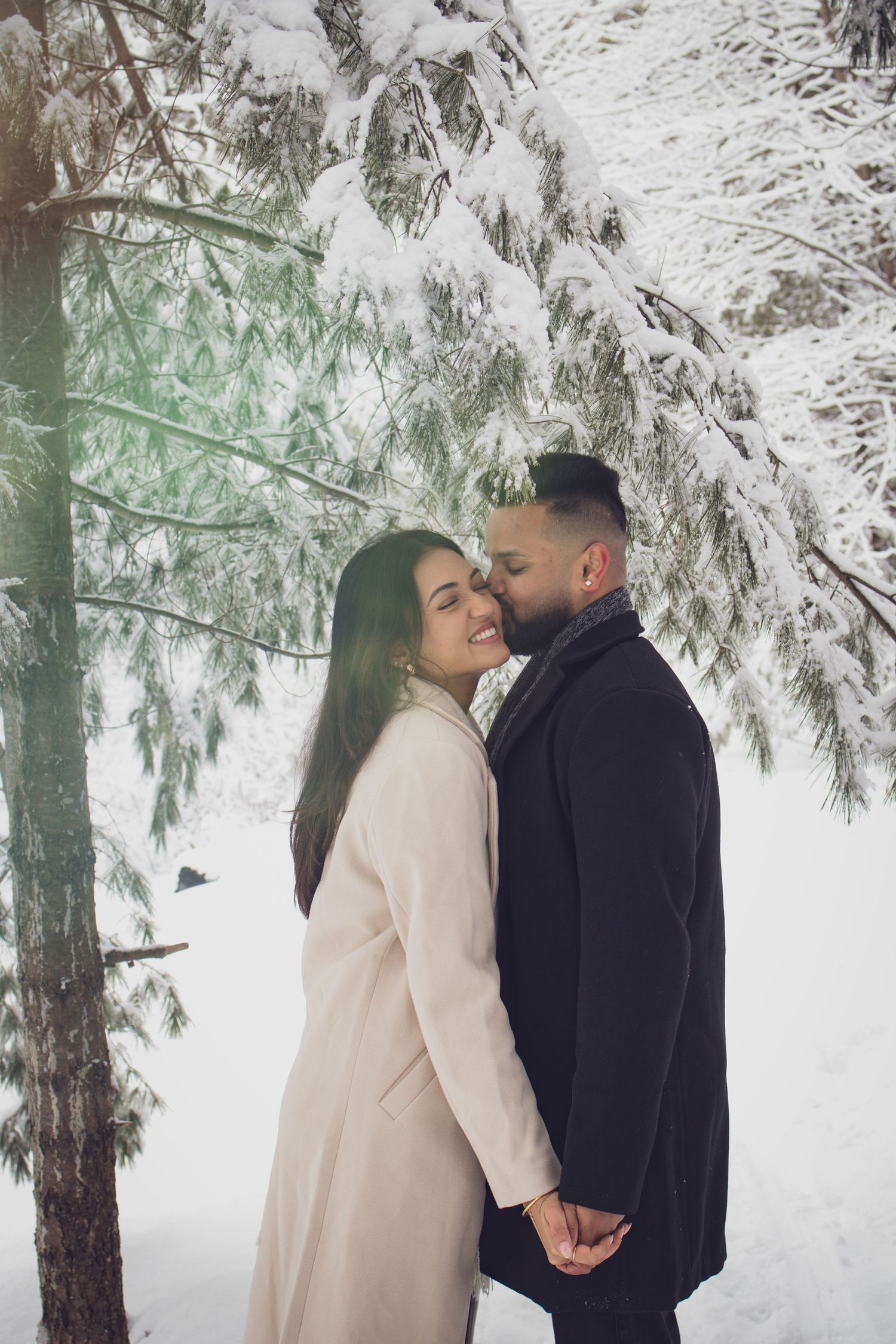 Andover couple photographer capturing a romantic winter session of a couple holding hands and walking through falling snow.