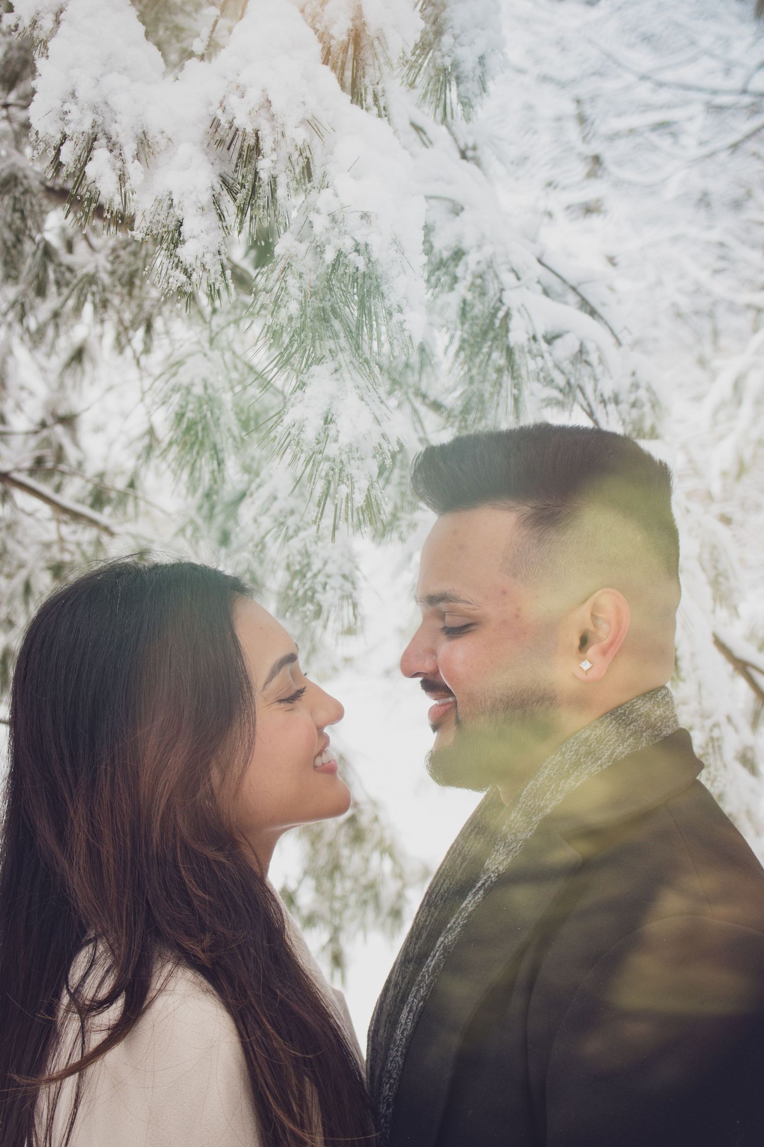 Andover couple photographer capturing a romantic winter session of a couple holding hands and walking through falling snow.