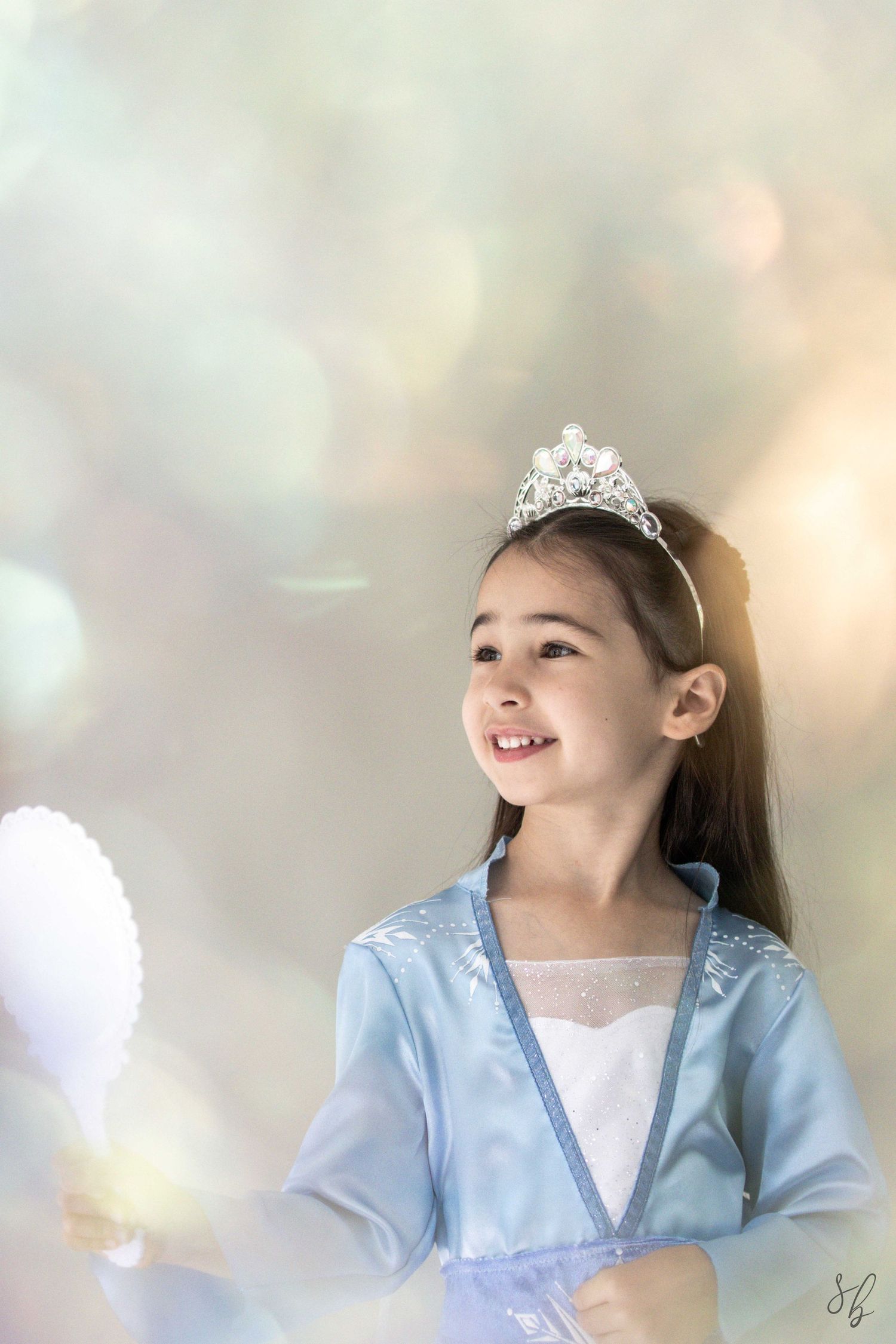 Andover children’s photographer capturing a dreamy personality portrait of a young girl in a blue princess costume and jeweled tiara.