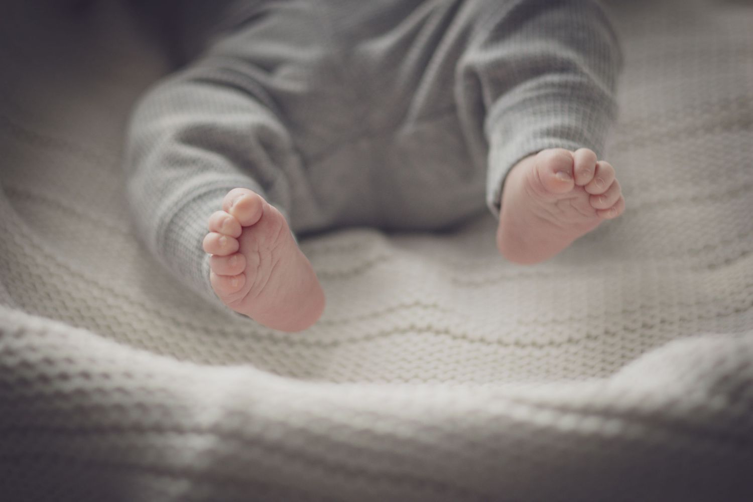 Close‑up newborn detail photo of tiny hands and feet captured by an Andover newborn photographer.